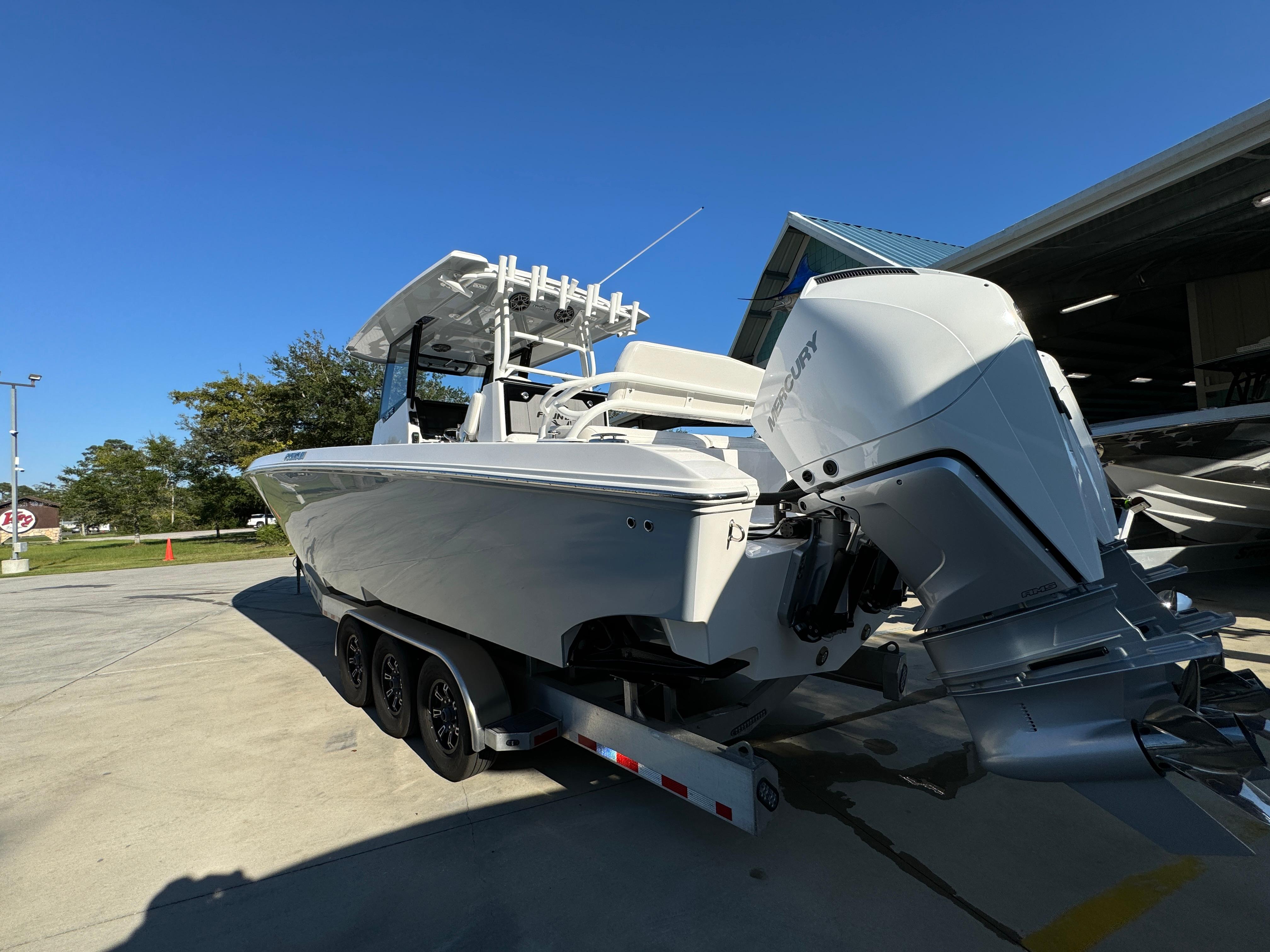 2025 Fountain 38TE boat on trailer, parked outdoors under clear blue sky.