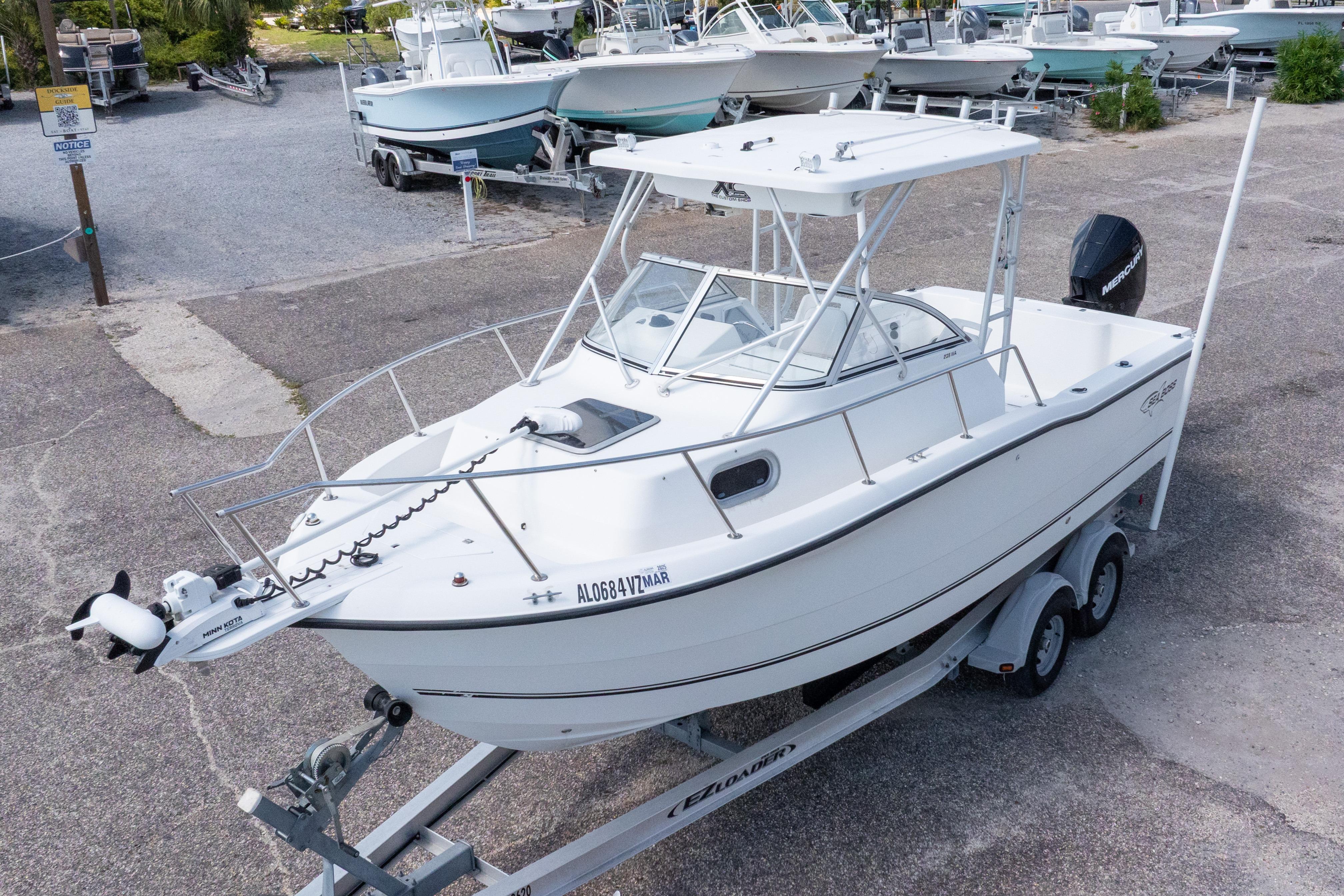 2007 Sea Boss 235 Walkaround boat on trailer in a marina setting.