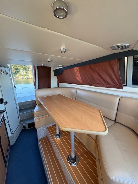 Interior of a 2008 Bayliner Discovery with dining table and seating area.