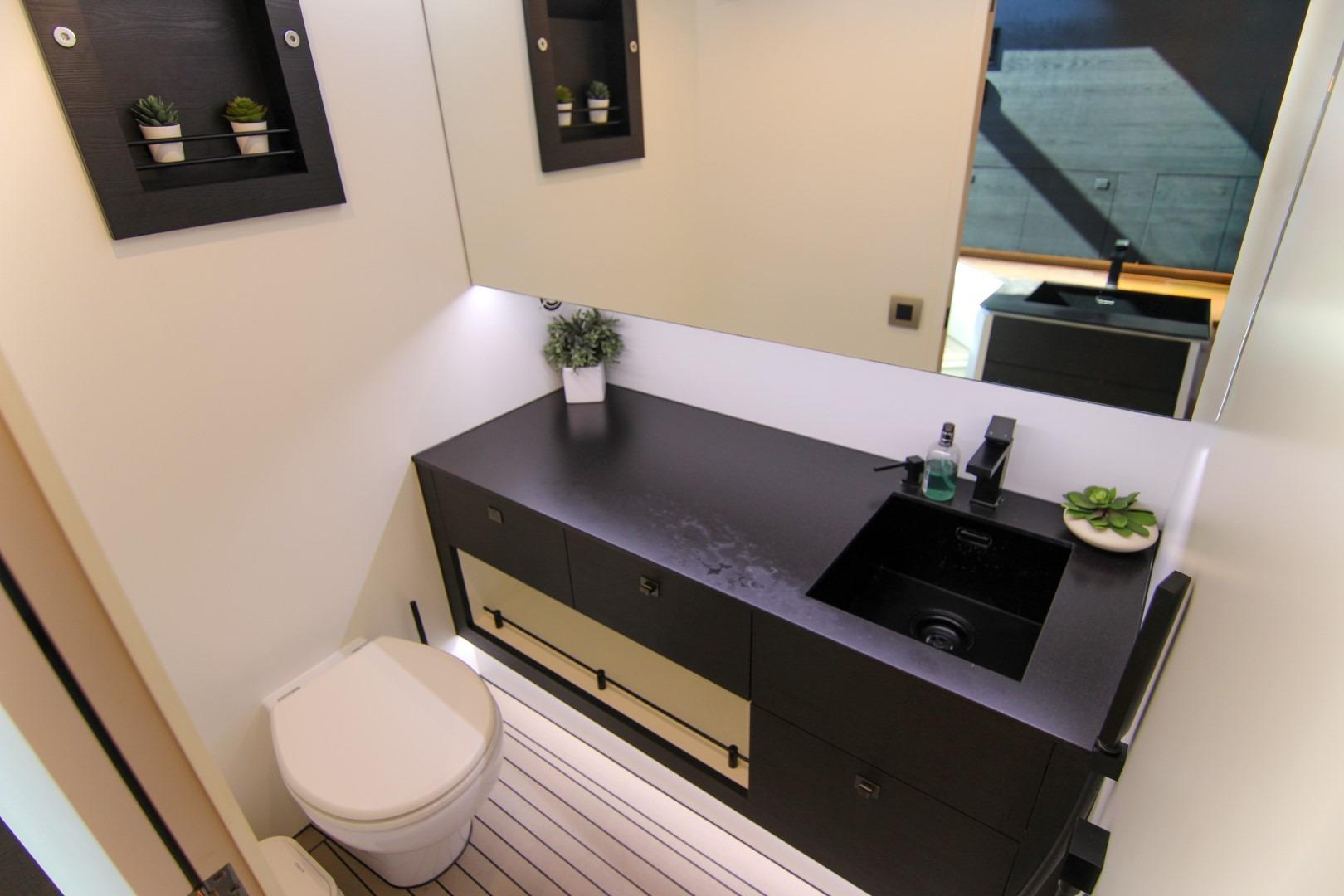 Modern bathroom interior on 2022 Vanquish Yachts VQ45, featuring sleek black fixtures and minimalist design.