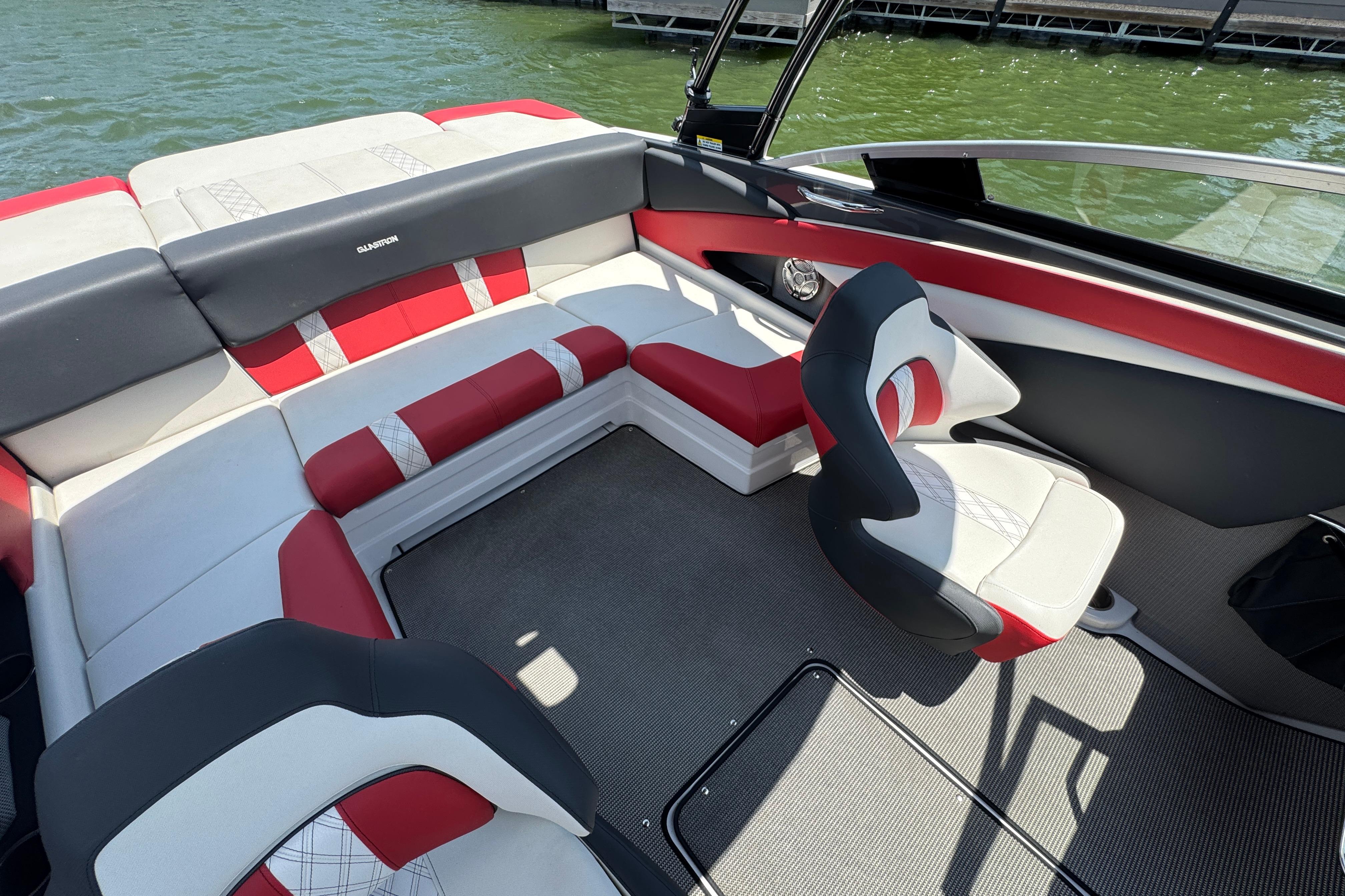 2017 Glastron GT 225 boat interior with red and white seating, on a lake.
