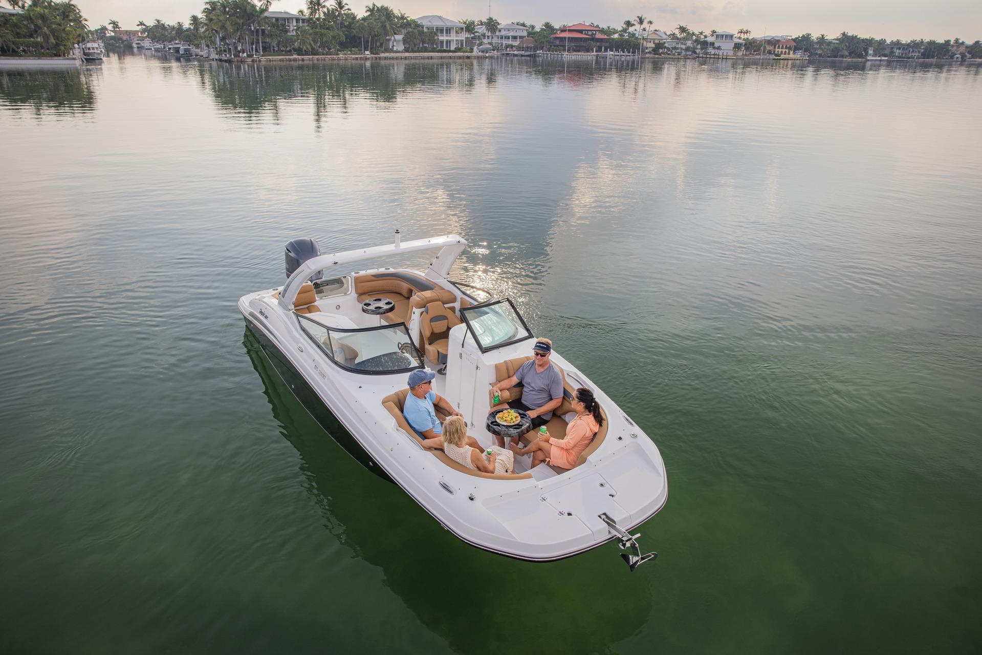 2026 Hurricane SunDeck 2690 OB boat with passengers enjoying a calm lake view.