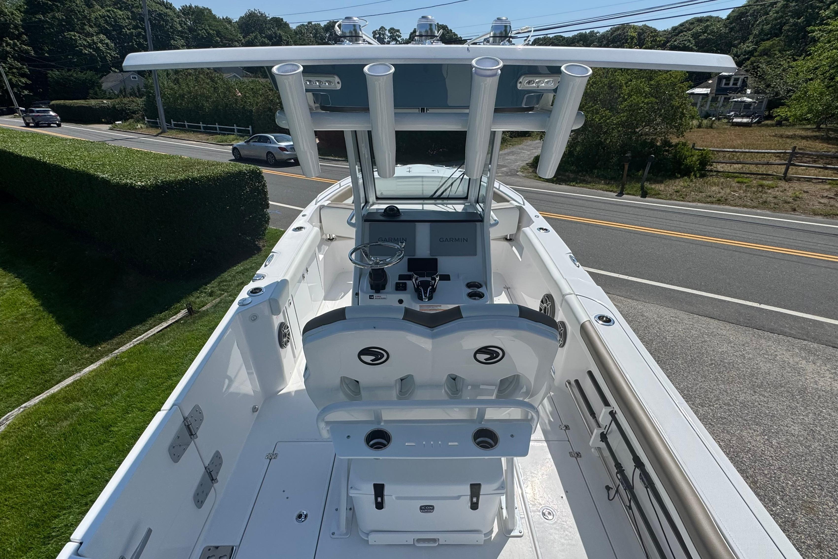 2026 Edgewater 250CC boat with modern console and seating, parked near a road.