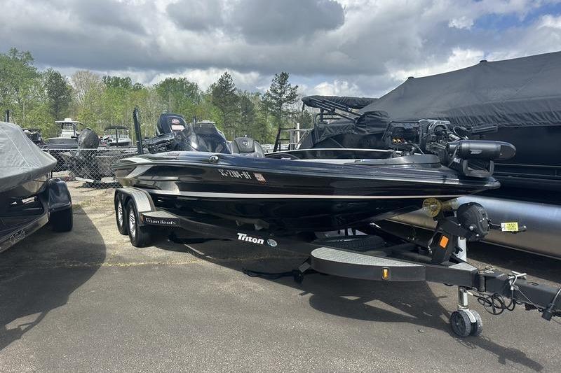 2016 Triton 20 TrX boat parked outdoors under cloudy sky.