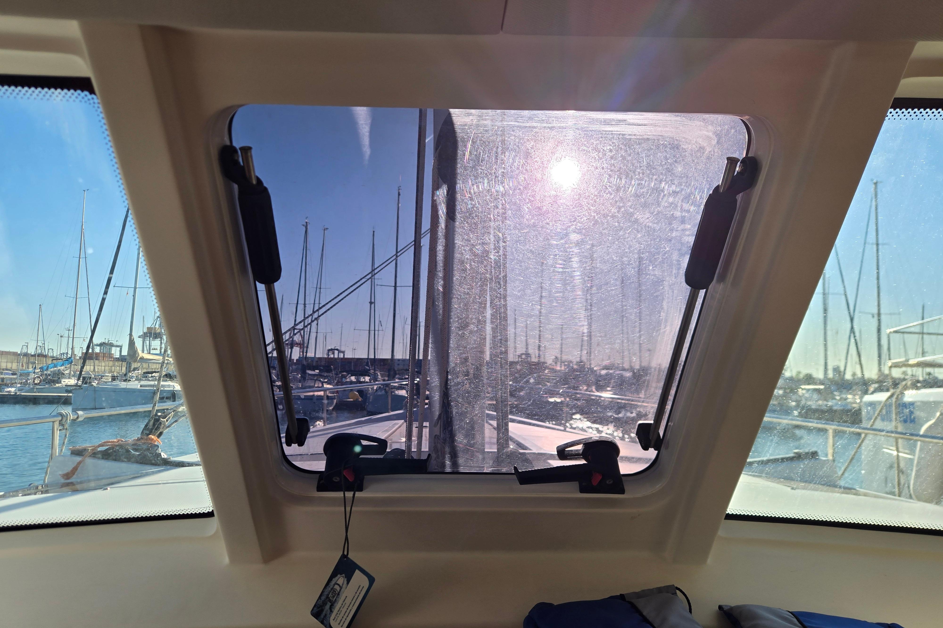 View from inside a 2020 Moody 45 DS yacht, overlooking a sunny marina.