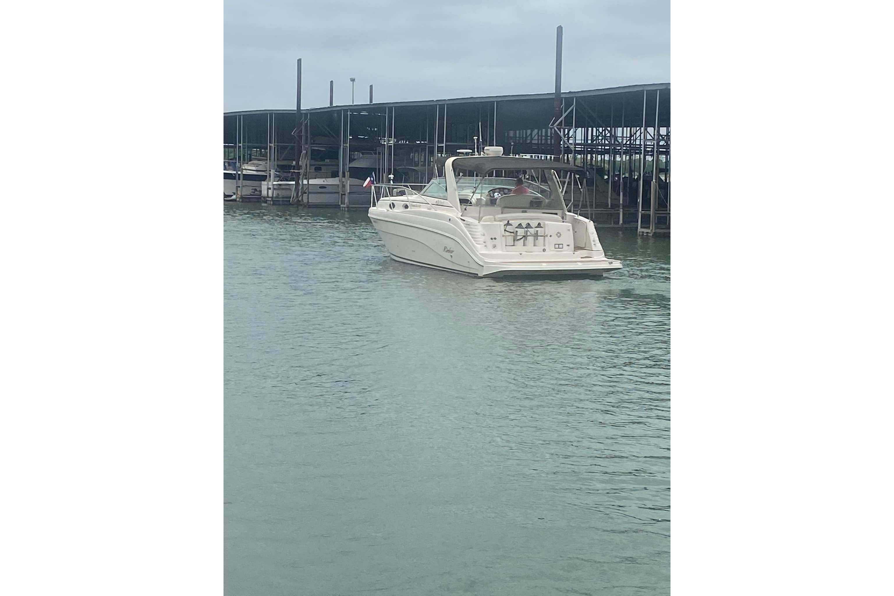 2003 Rinker 342 Express Cruiser docked in a marina, rear view.