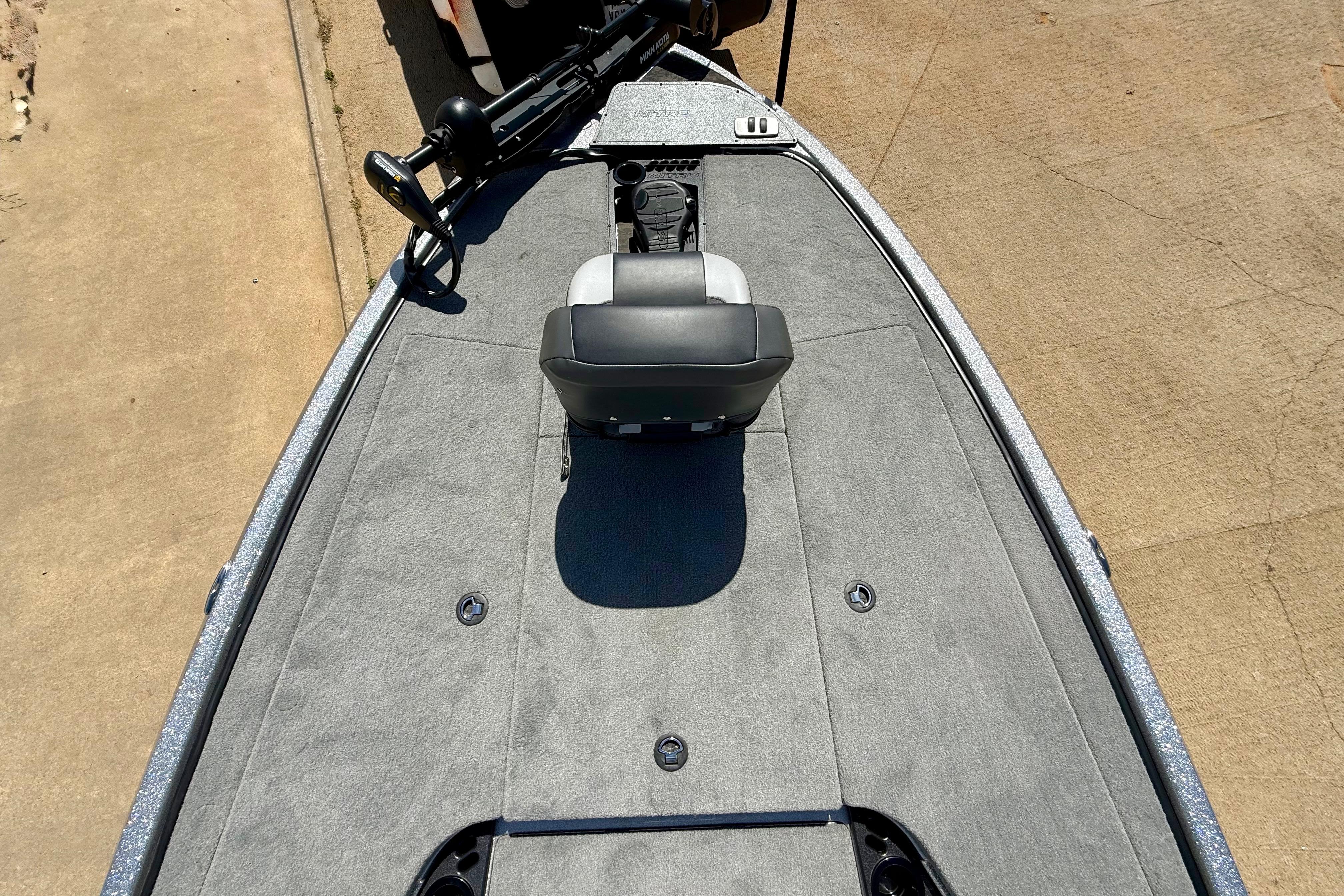 2026 Nitro Z19 XL boat deck with seating and equipment, parked on concrete.