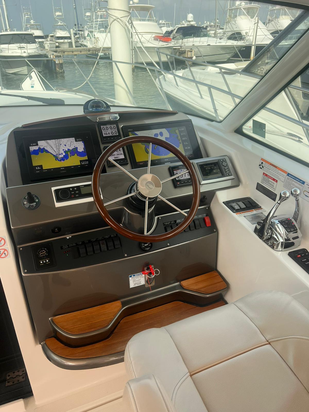 2014 Tiara Yachts 39 Coronet helm station with navigation screens and steering wheel.