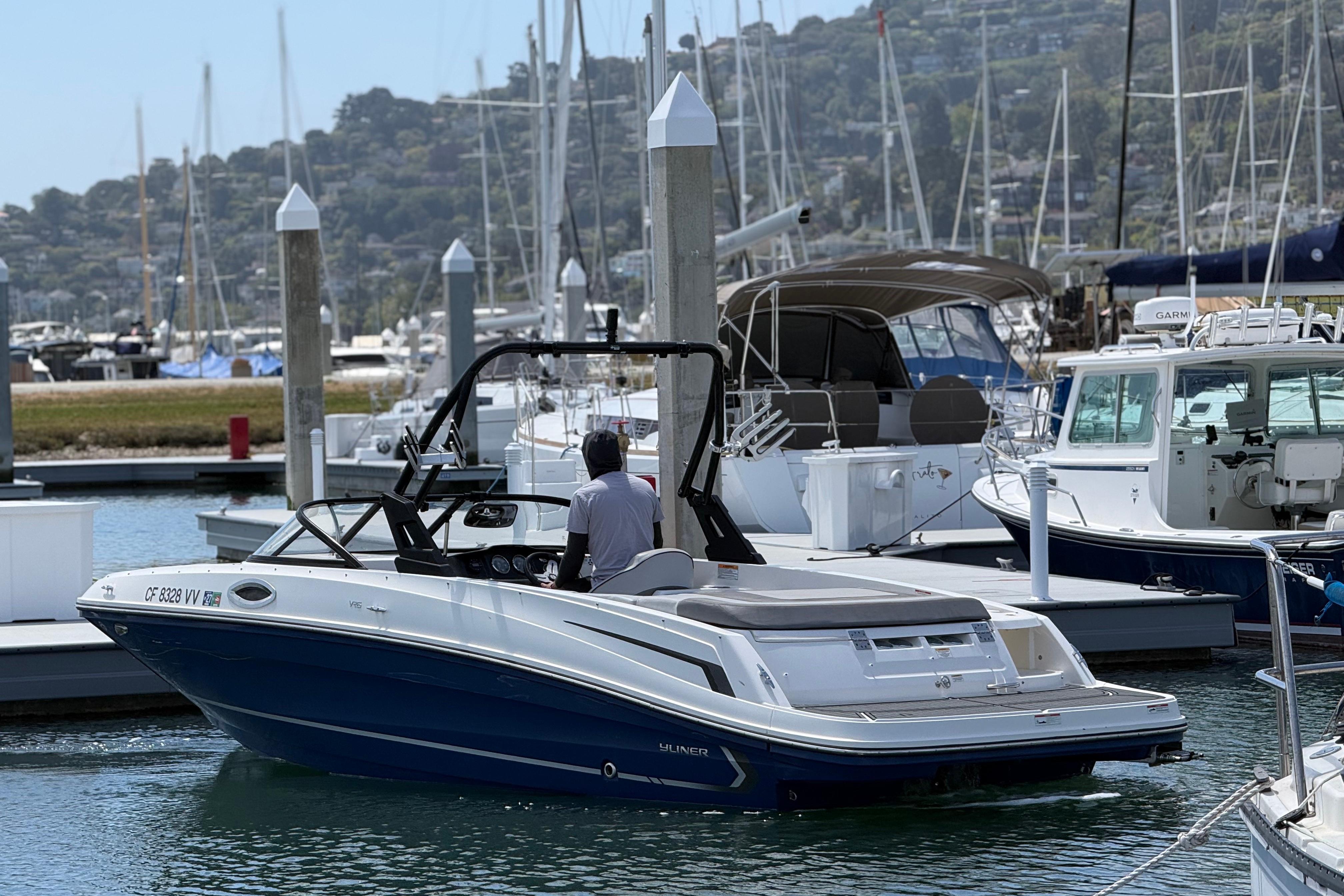 2021 Bayliner VR5 Bowrider I/O docked at a marina with scenic background.