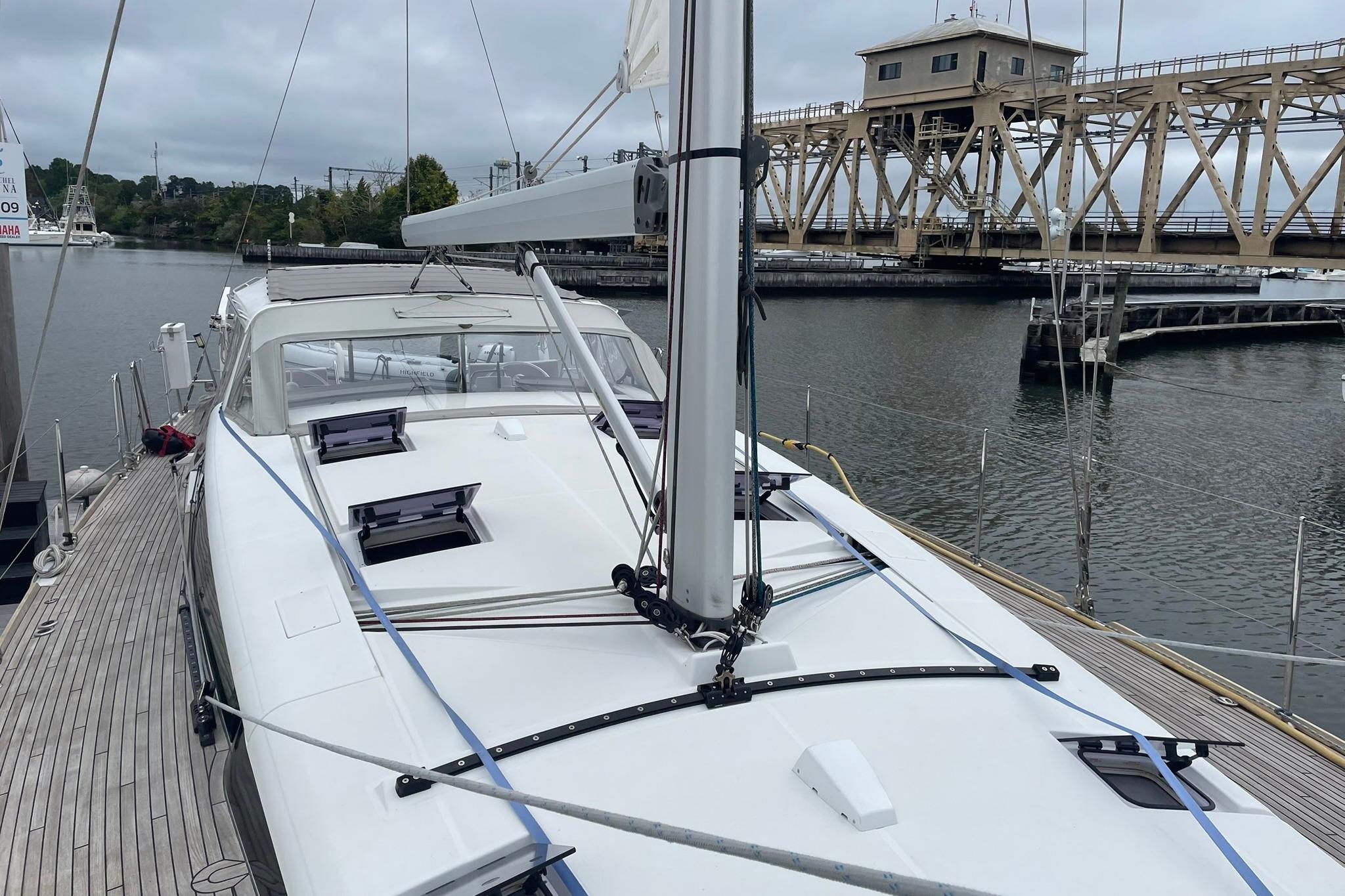 2017 Beneteau Sense 50 yacht docked near a bridge on a cloudy day.
