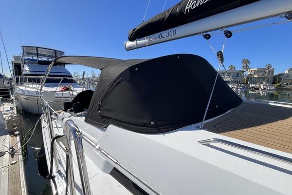 2025 Hanse 360 yacht docked at marina, featuring sleek design and covered cockpit.