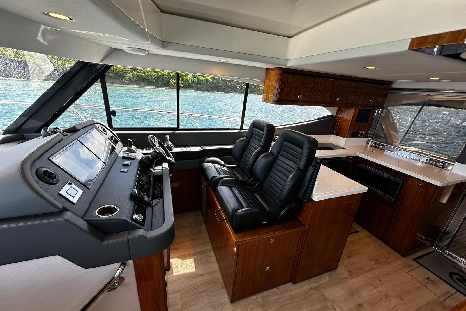 Interior of 2023 Riviera 465 SUV yacht with modern helm and luxurious seating.