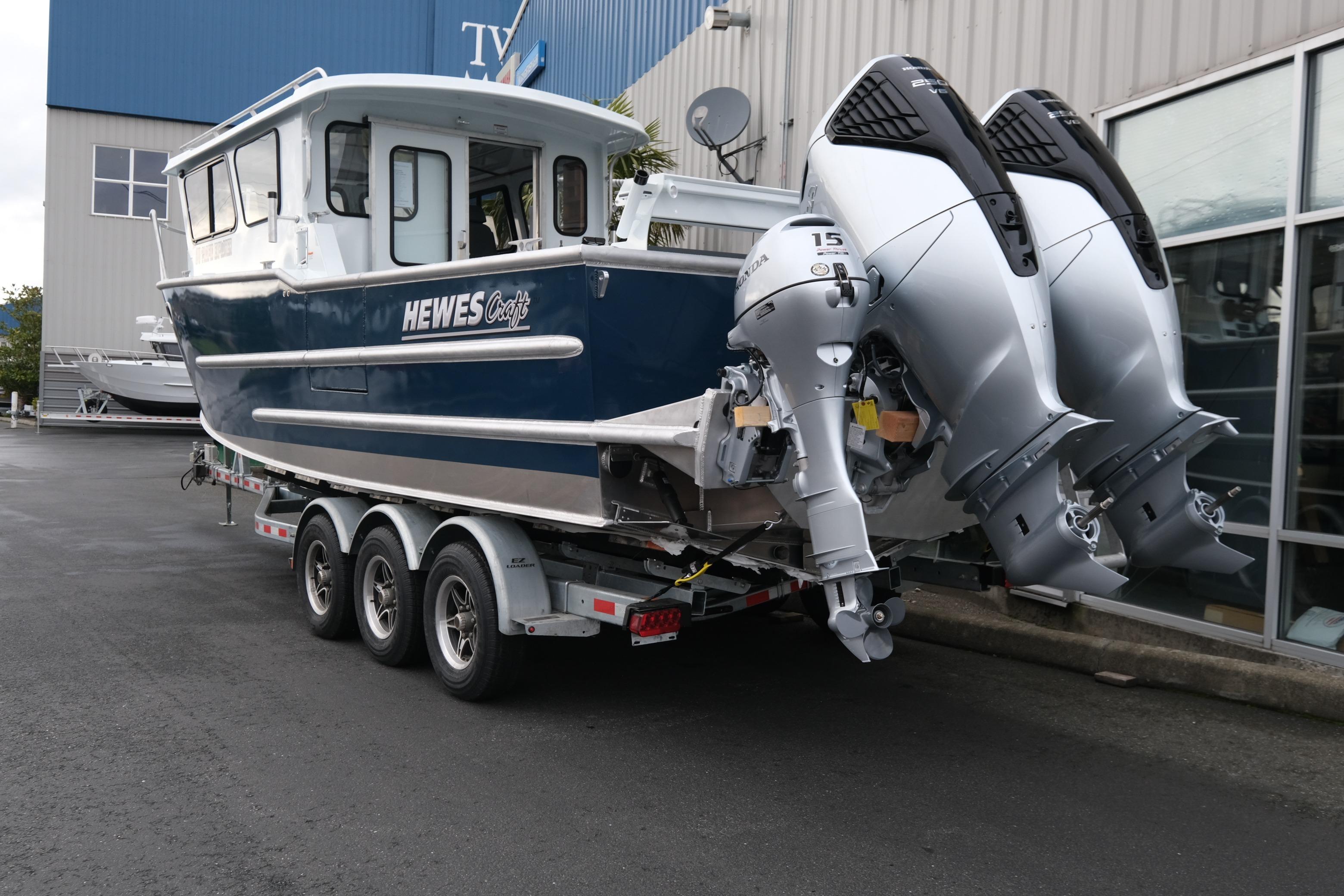2026 Hewescraft 270 Pacific Explorer boat on trailer with dual outboard motors.