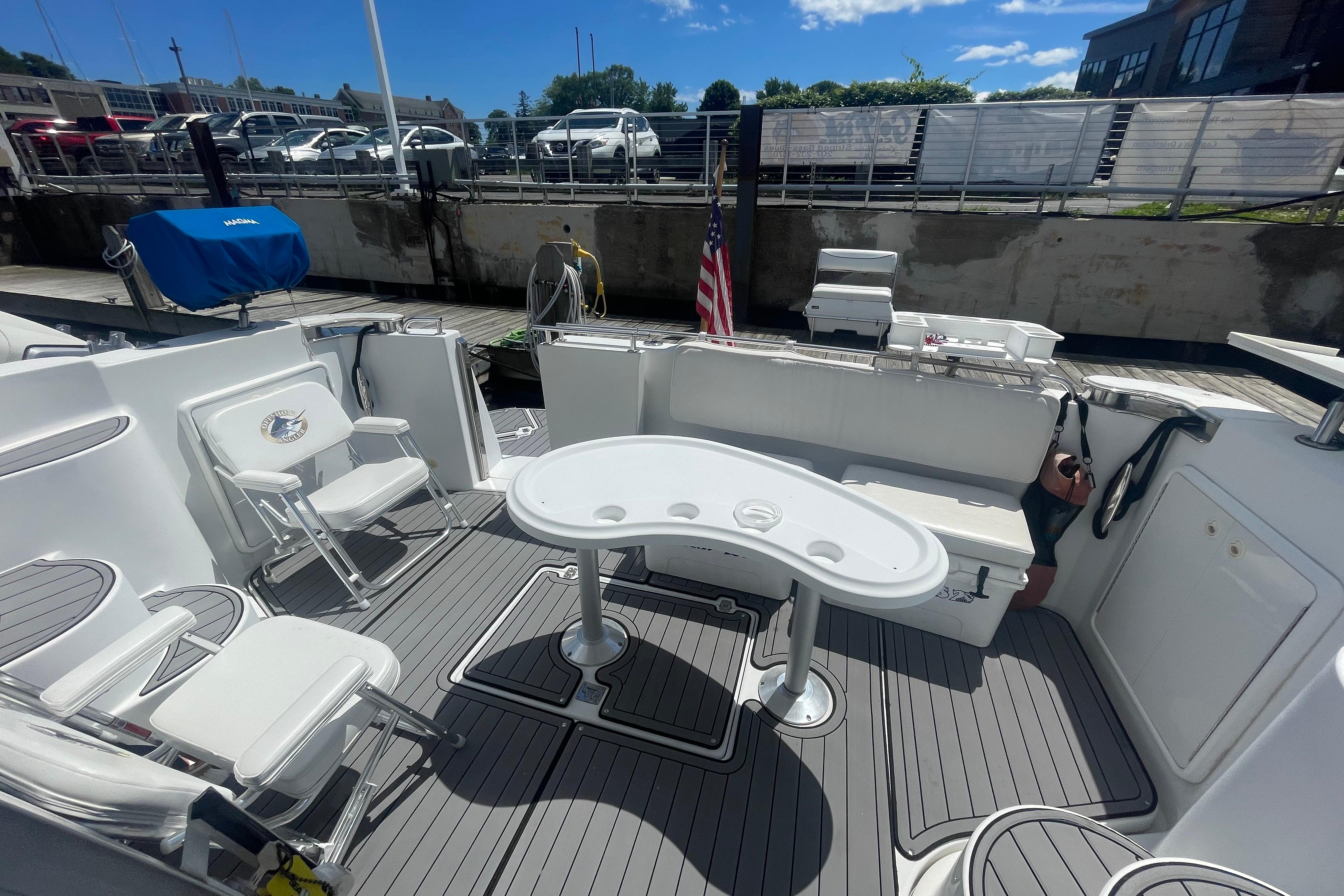 2002 Carver 410 Sport Sedan yacht deck with seating and table, docked under a clear sky.