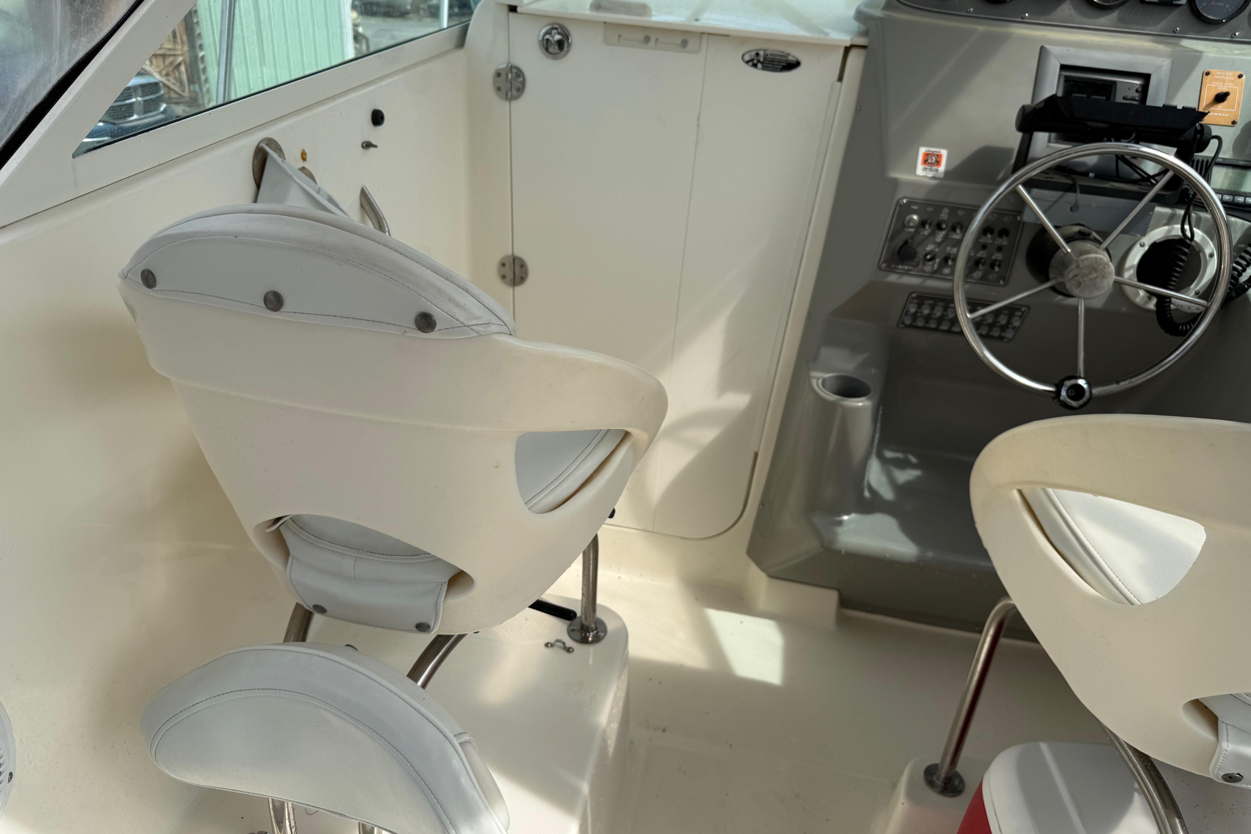 Interior of a 2006 Trophy 2502 Walkaround boat with steering wheel and seating.