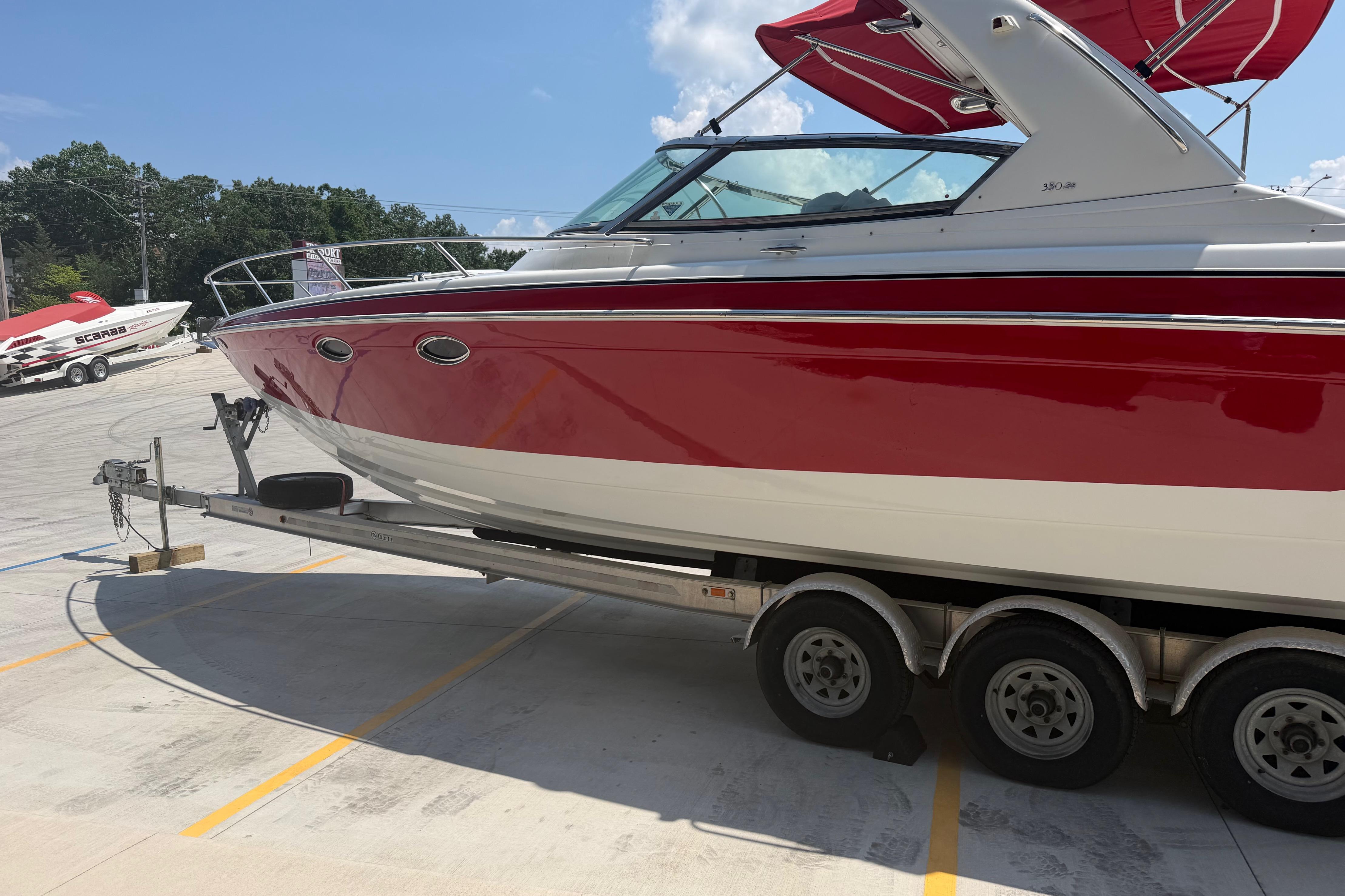 2006 Formula 330 Sun Sport boat on trailer, red and white design, parked outdoors.