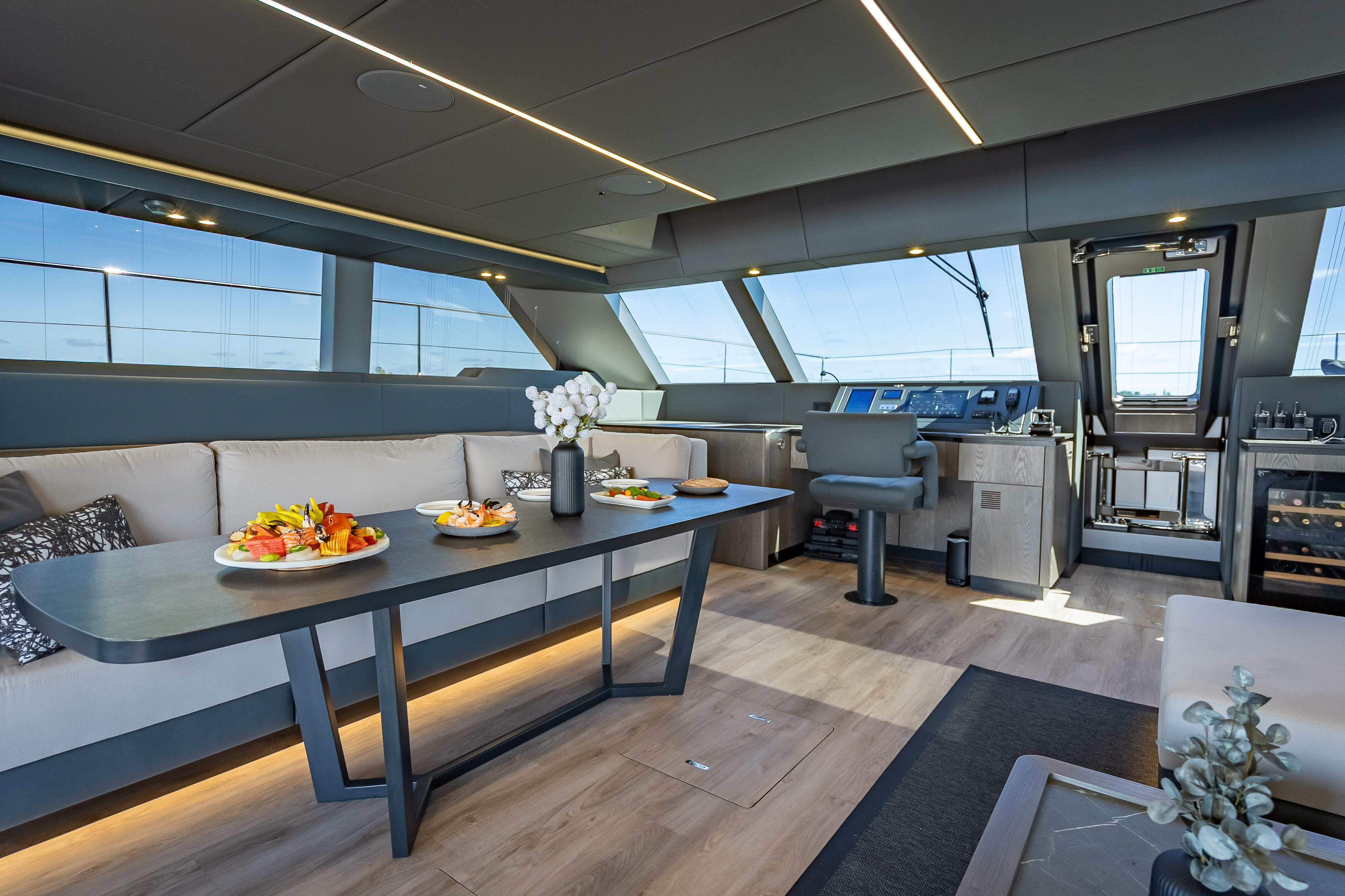 Luxurious interior of 2026 Sunreef 60 Power yacht with elegant dining area and modern helm.