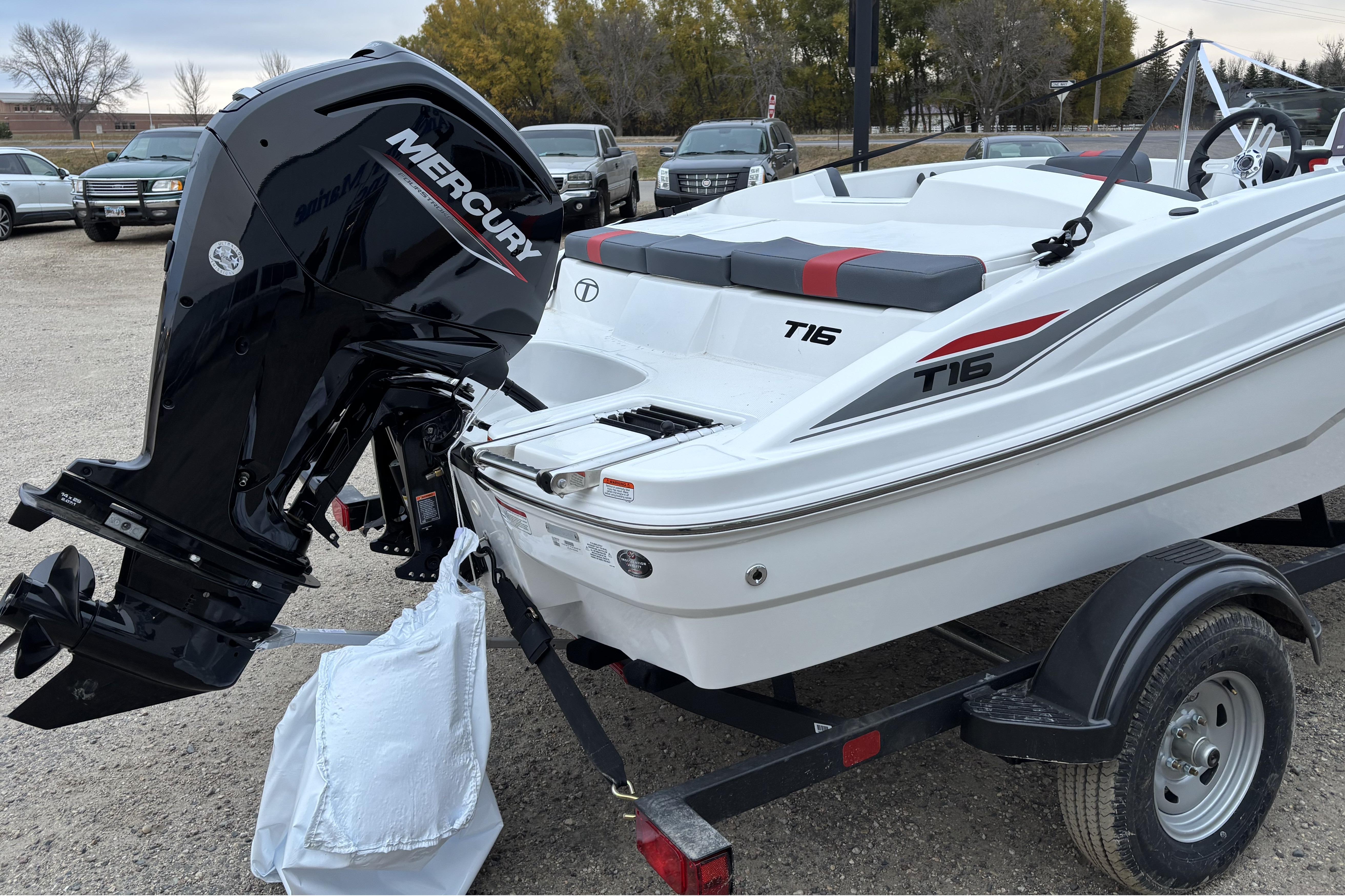 2026 Tahoe T16 boat with Mercury engine on trailer, parked outdoors.