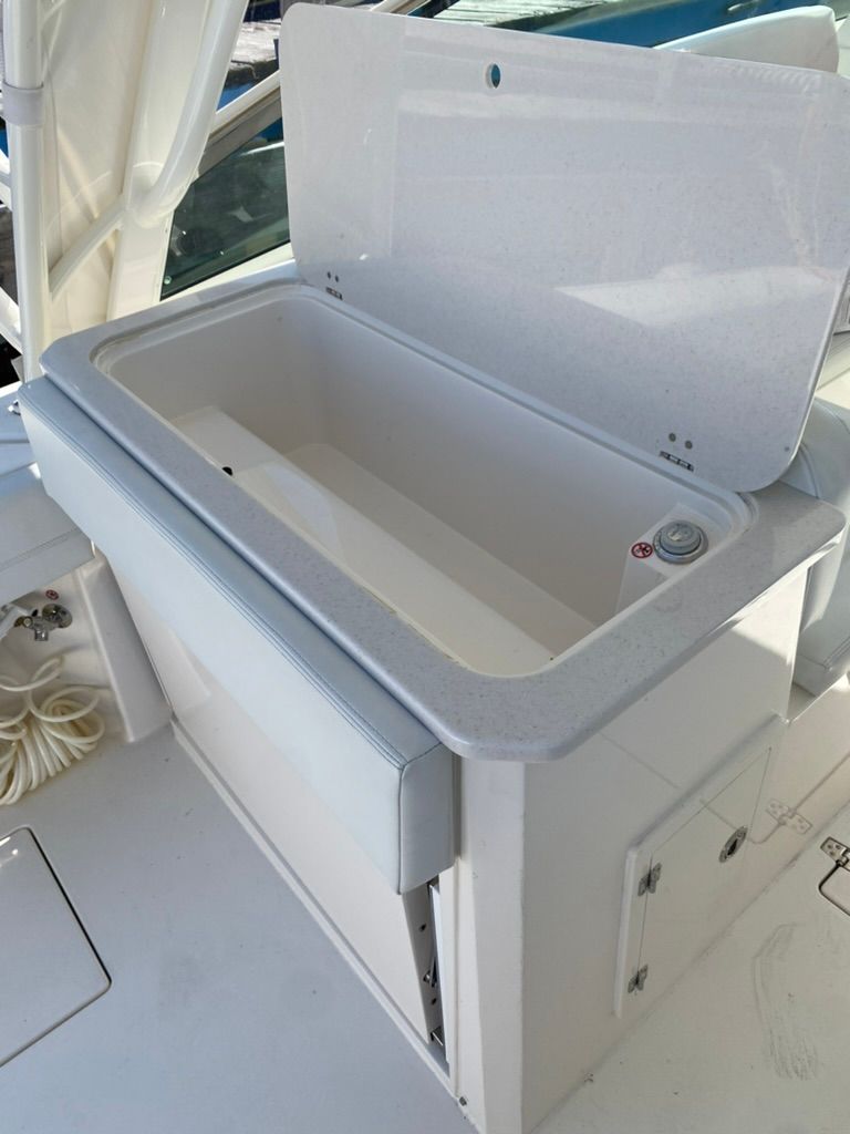 Open storage compartment on a 2023 Cobia 330 boat.