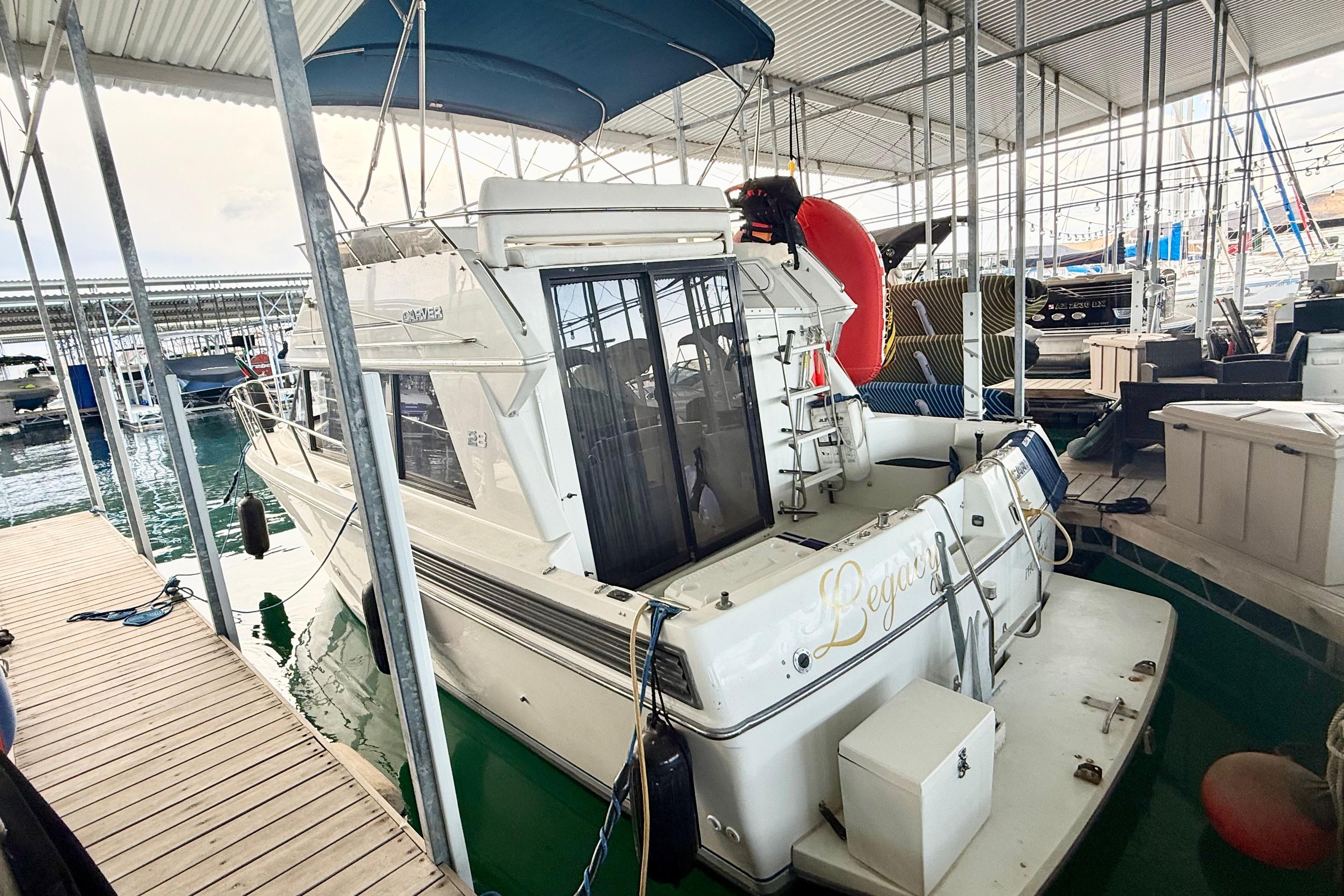 1992 Carver 28 Command Bridge docked in a marina, featuring a covered deck and spacious interior.