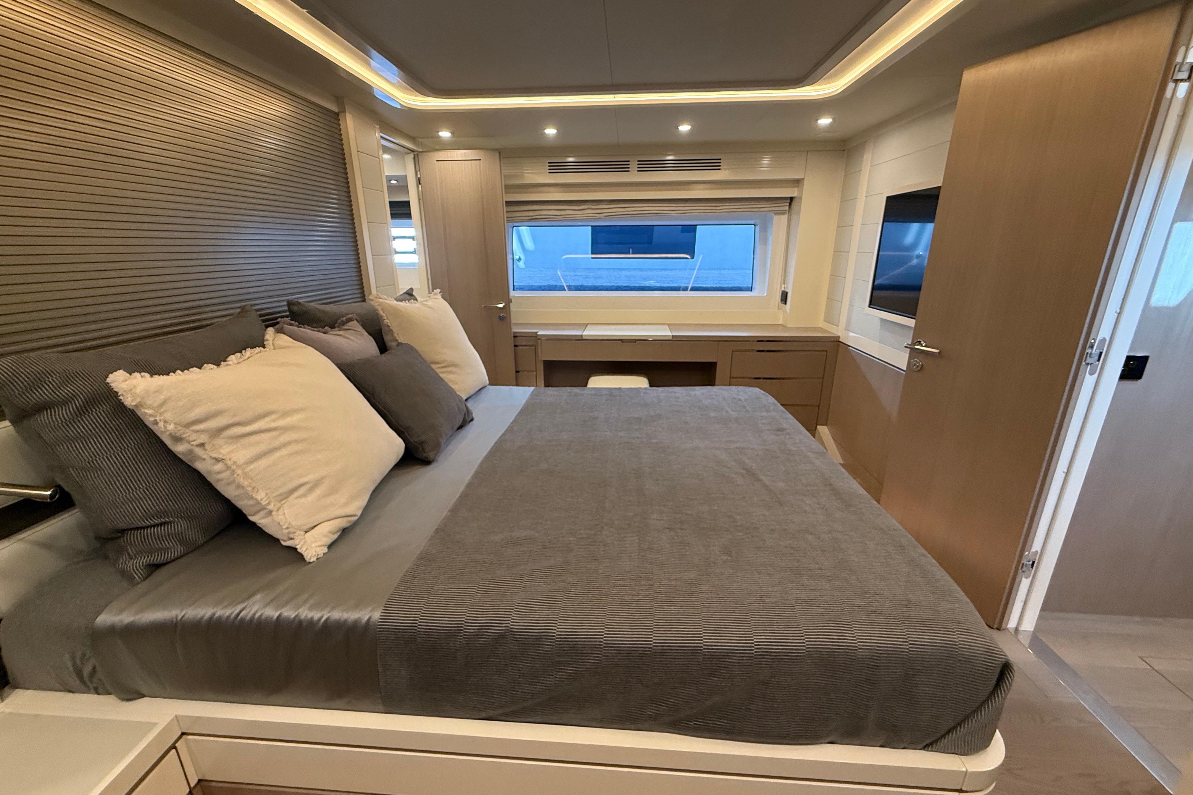 Luxurious bedroom interior of 2026 Sirena 68 yacht with modern design and cozy bedding.