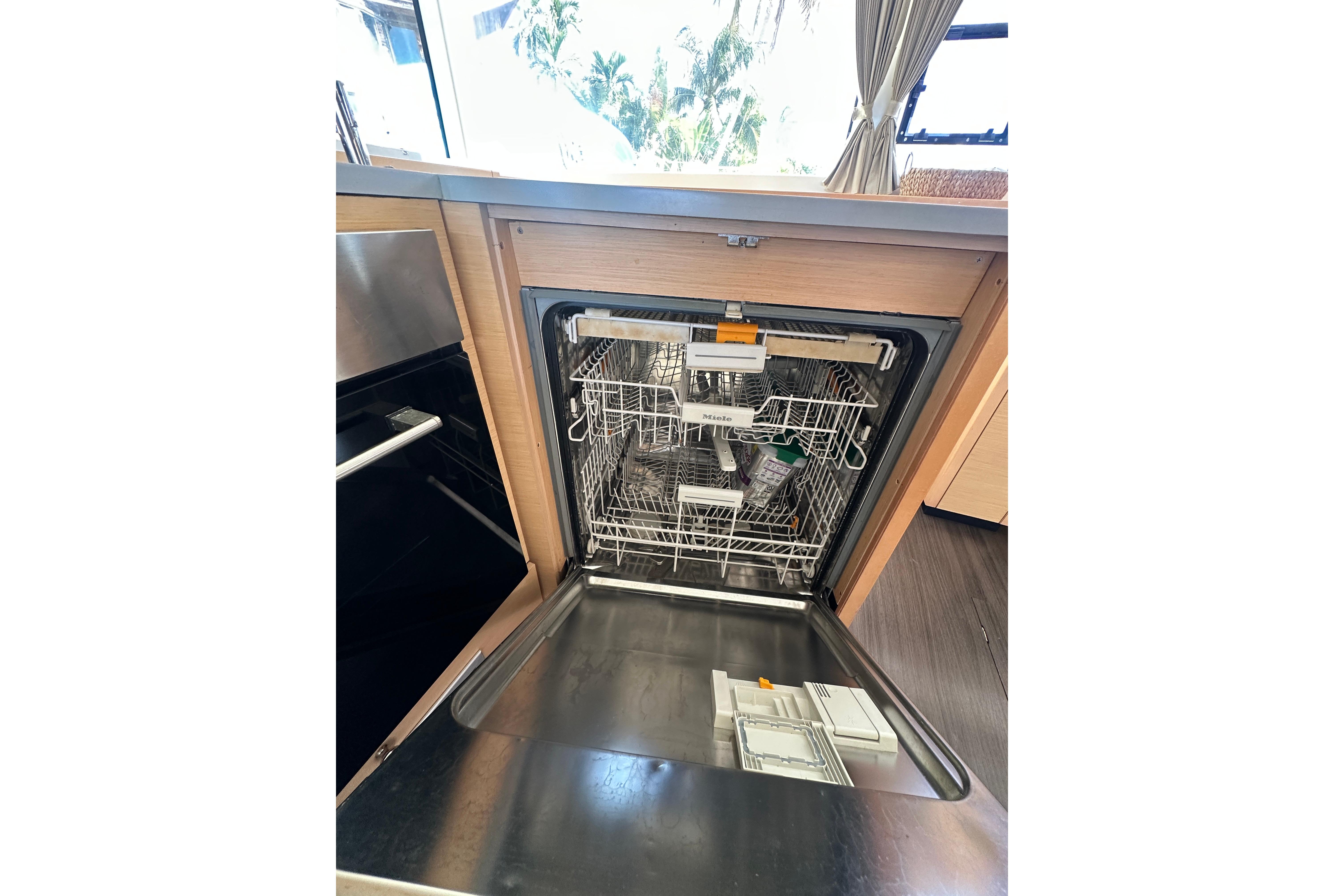 Open dishwasher in Lagoon 52 F yacht kitchen, showcasing modern interior design.