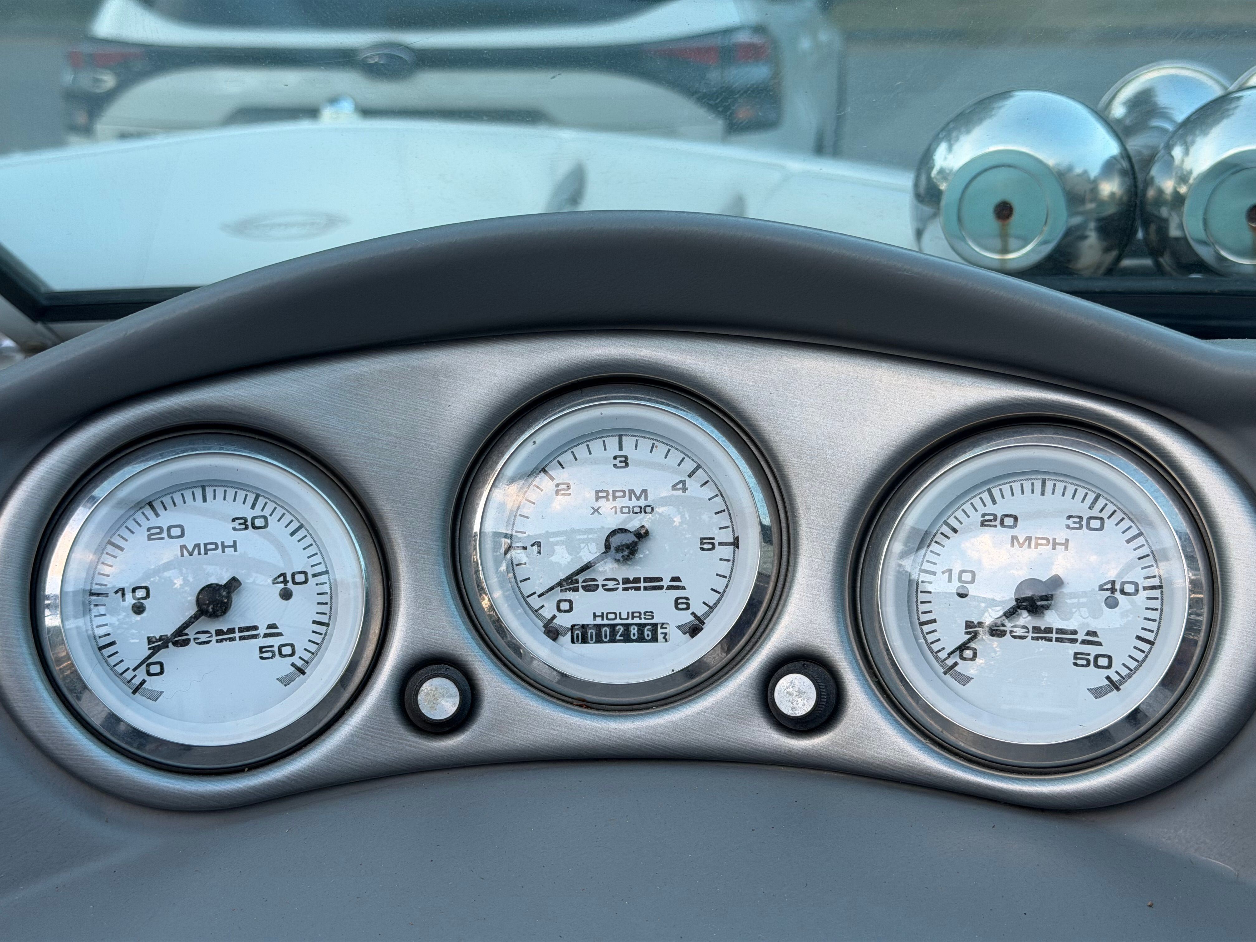 Dashboard of a Moomba Outback boat with speed and RPM gauges.