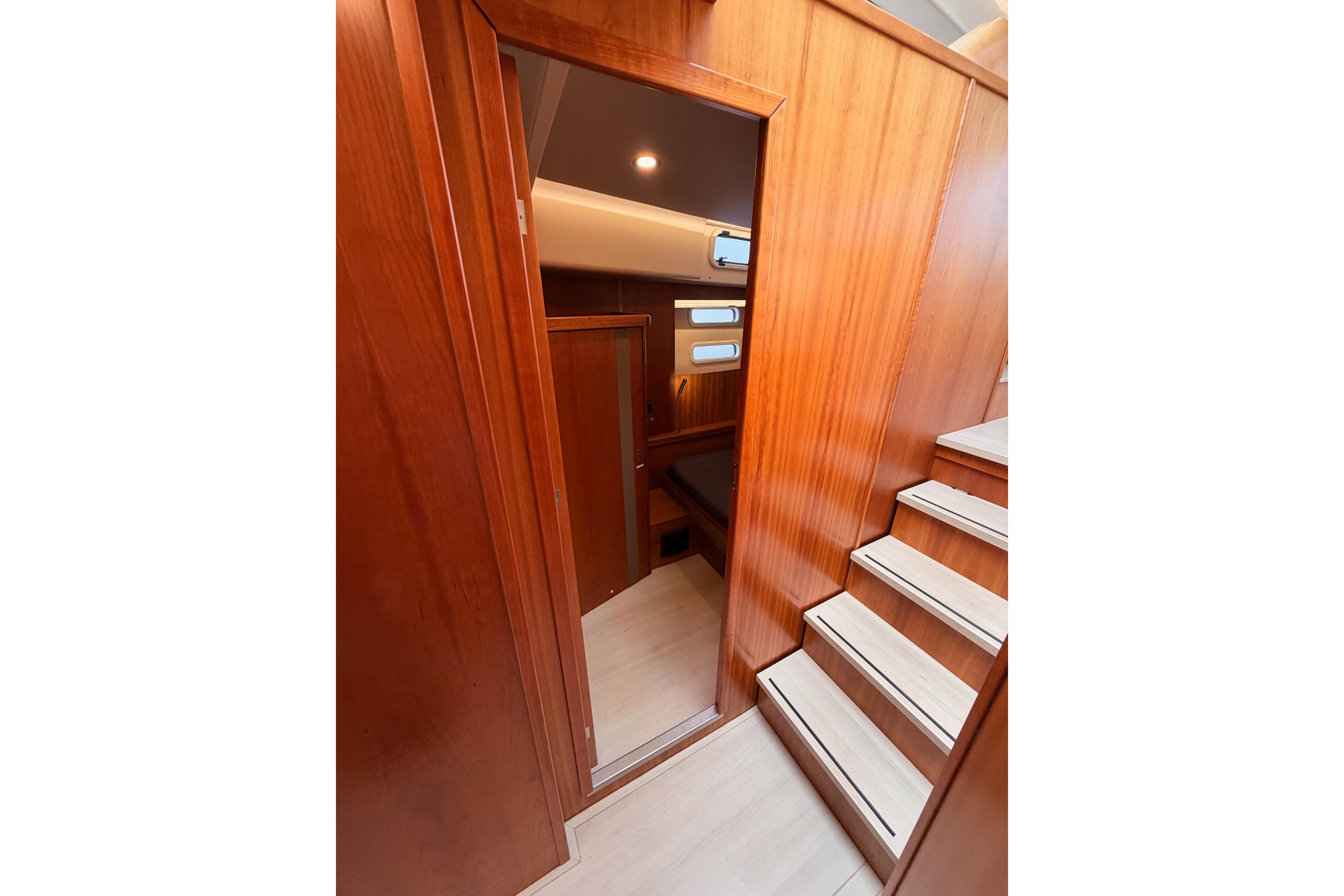Interior of 2016 Moody Decksaloon 54 yacht with wooden paneling and stairs.