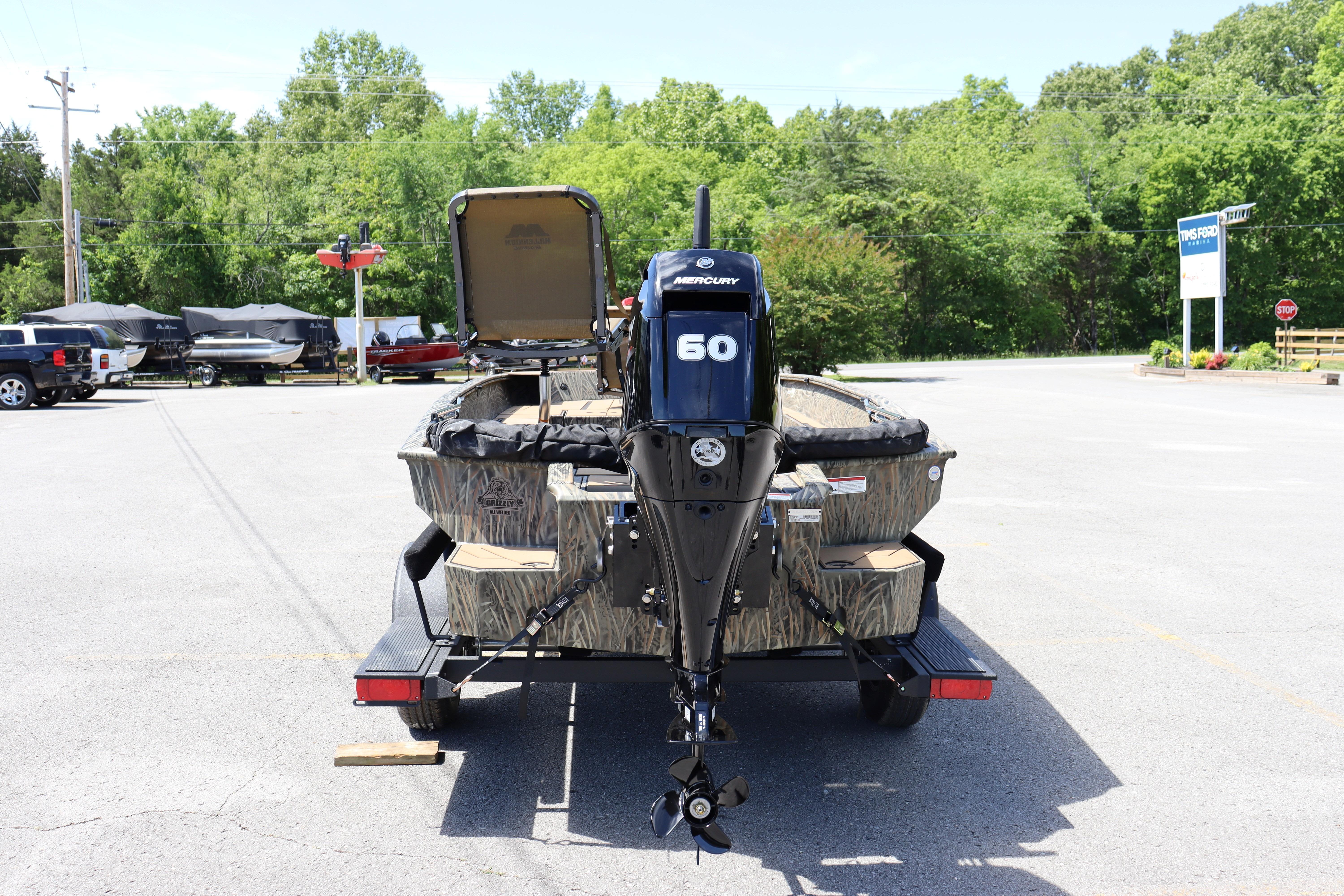 2026 Tracker Grizzly 1756 T Marsh boat with Mercury 60 engine in parking lot.