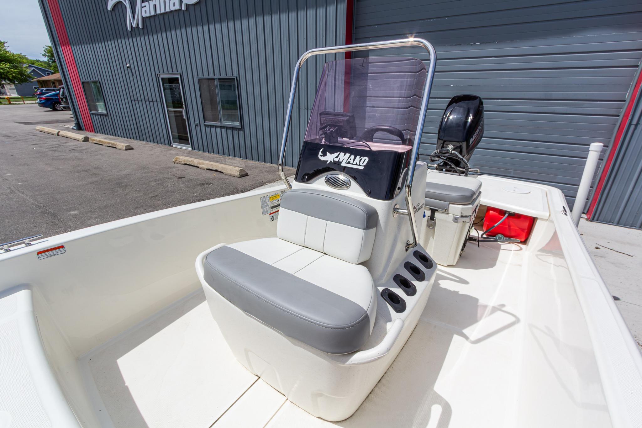 2020 Mako Pro Skiff 15 CC boat with console and seating, parked outside a building.