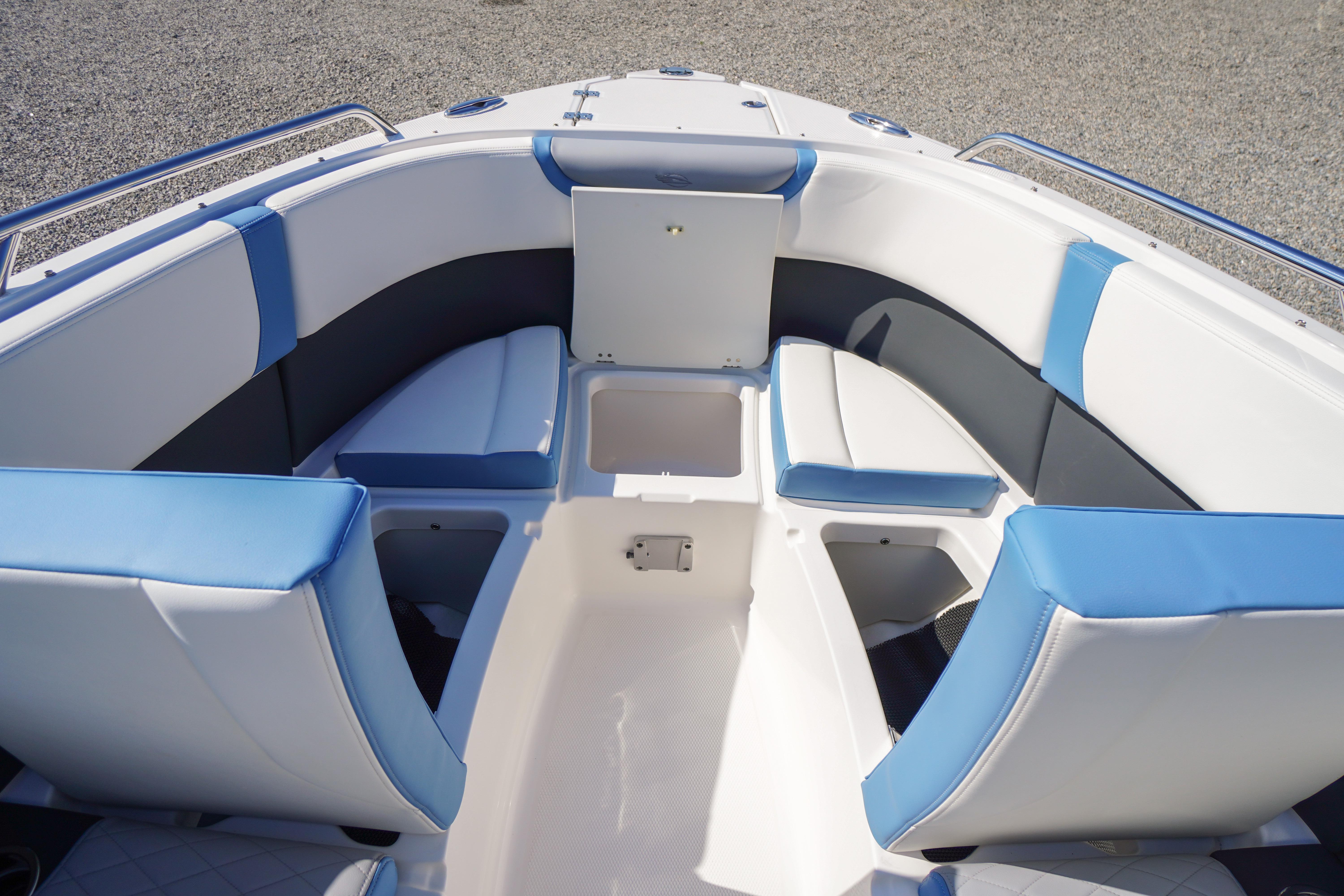 2026 Chaparral 270 OSX boat interior with blue and white seating and storage compartments.