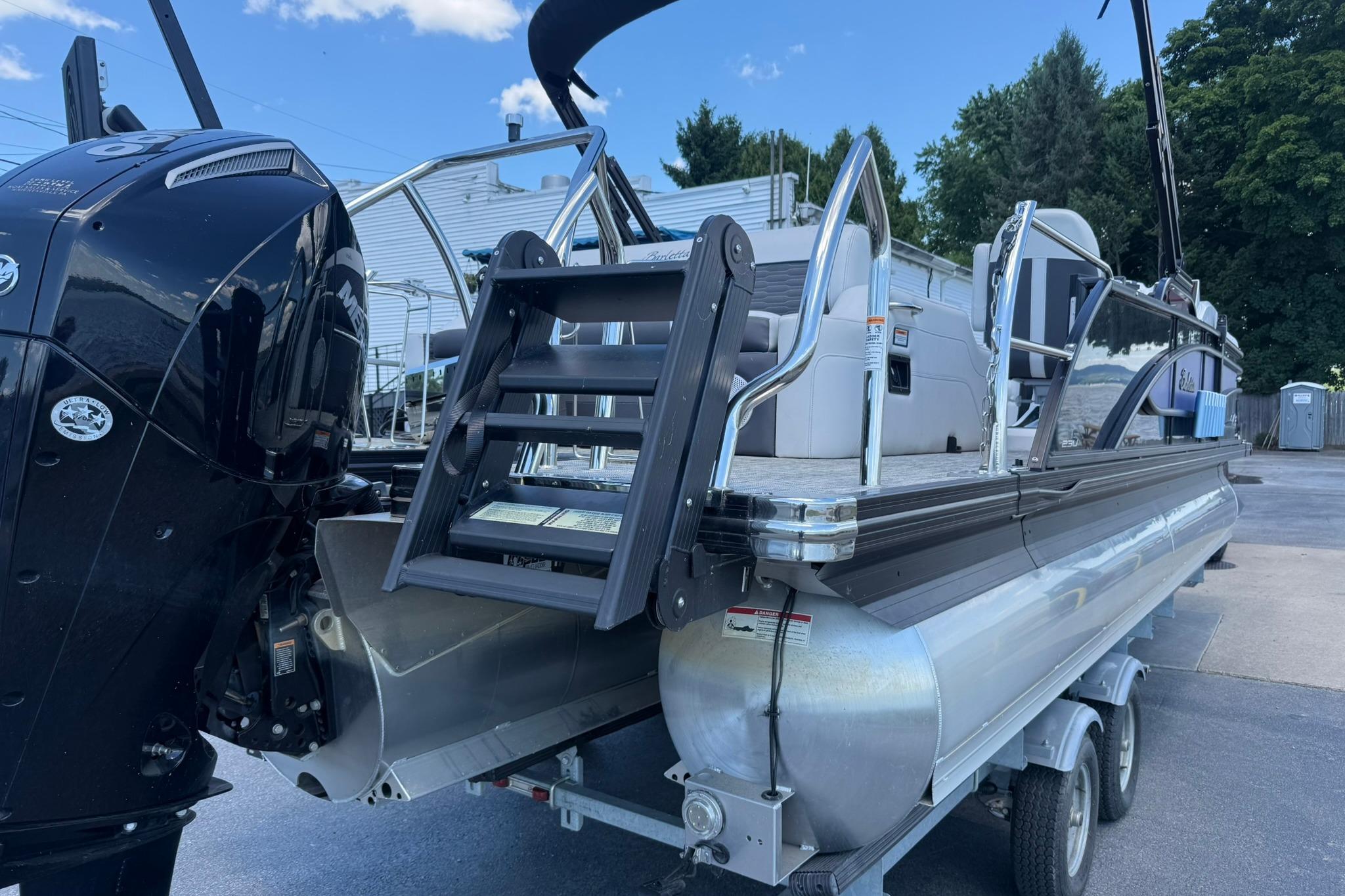 2023 Barletta Corsa 23U pontoon boat with outboard motor and boarding ladder.