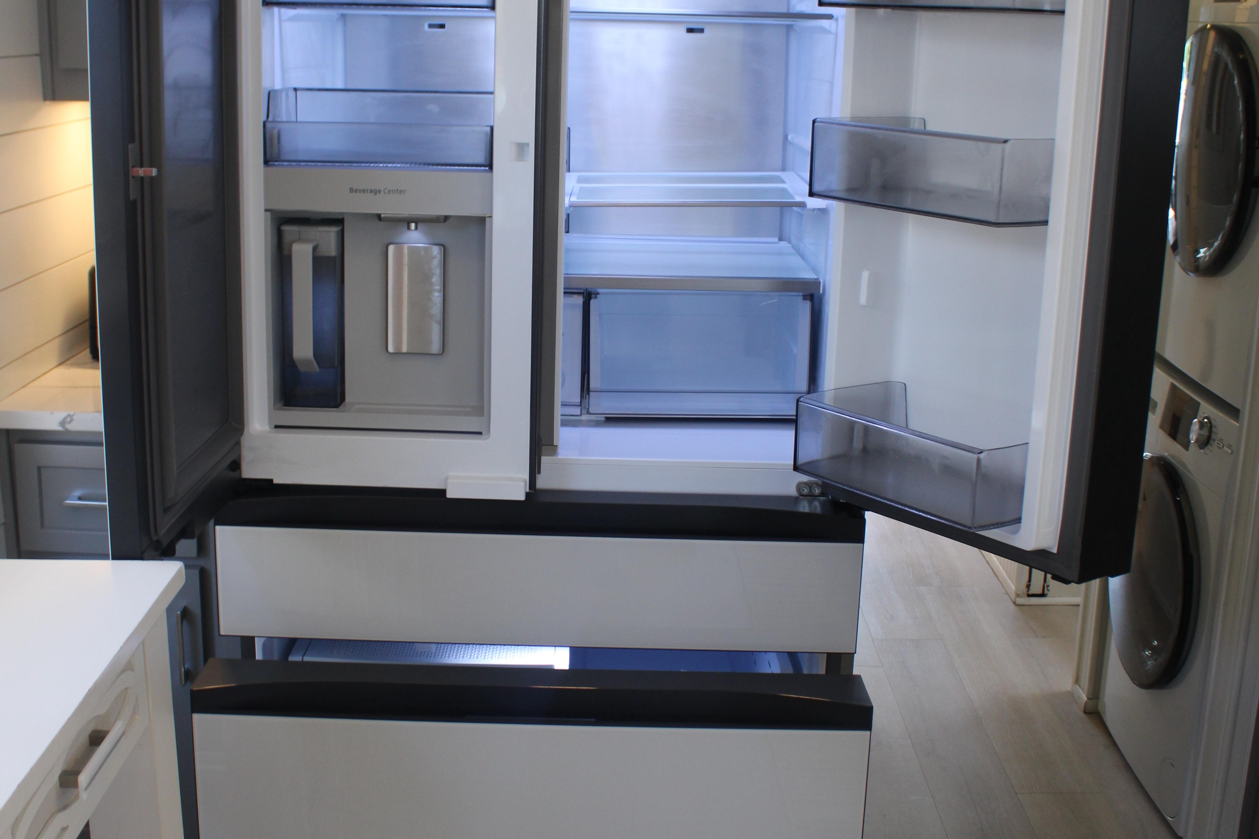 Modern kitchen refrigerator with open doors and spacious interior storage.