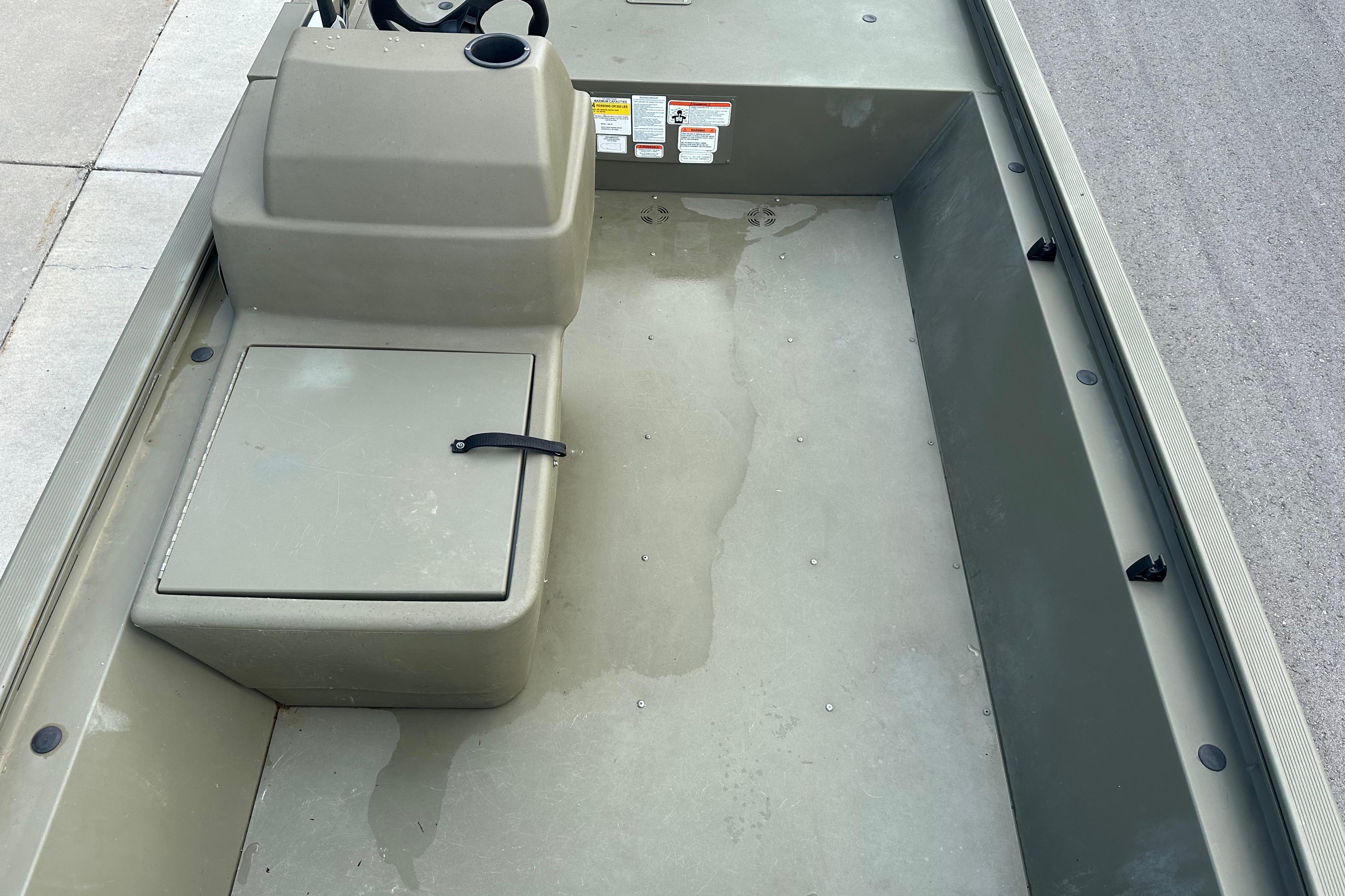 2024 Tracker Grizzly 1648 SC boat interior with storage compartment and steering console.