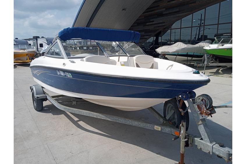2008 Bayliner 175 boat on trailer, blue and white, parked outdoors.