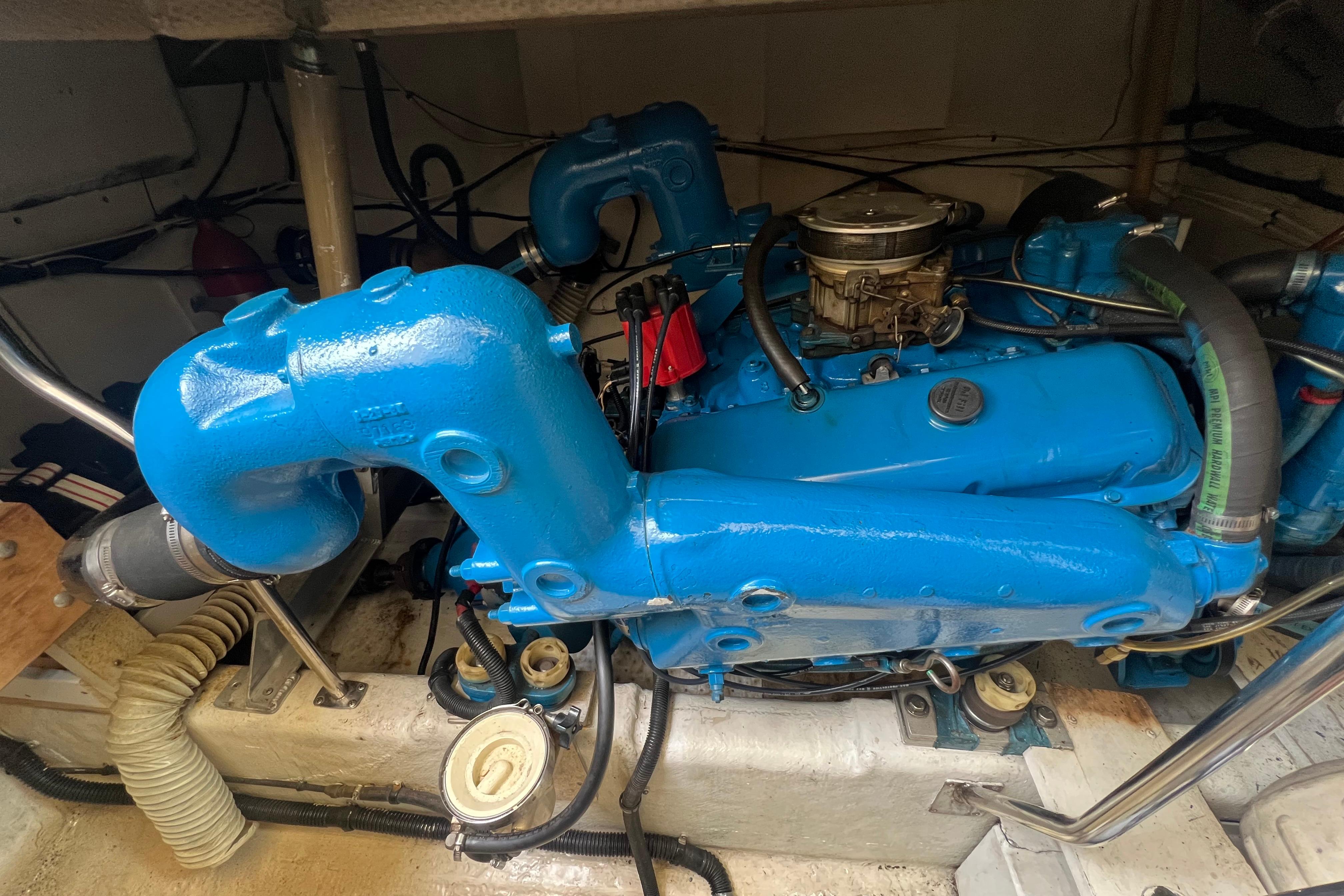 Engine of a 1985 Tiara 36 OPEN boat, featuring blue components and hoses.