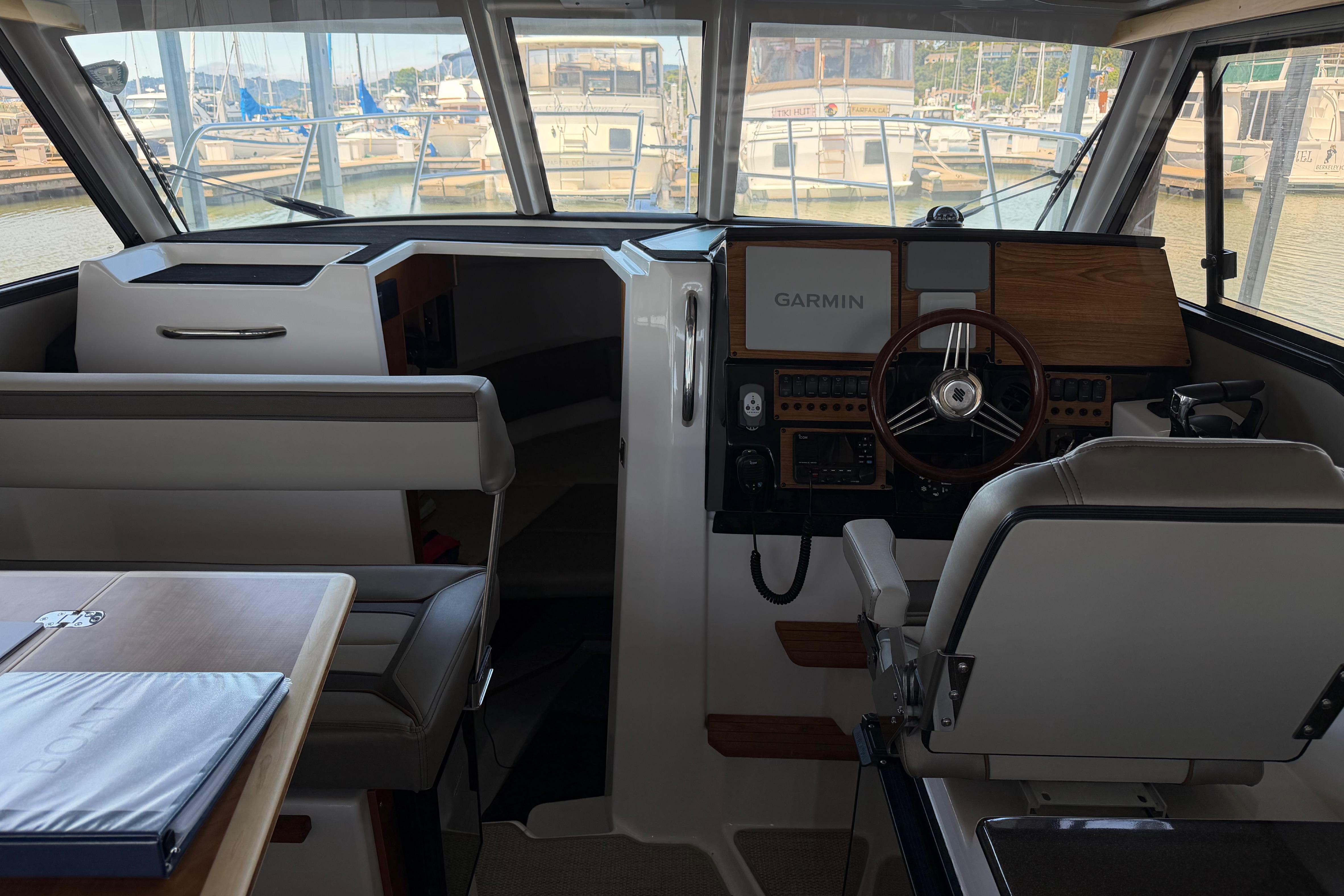 Interior of 2023 Cutwater C-288 Coupe boat, featuring helm with Garmin navigation system.