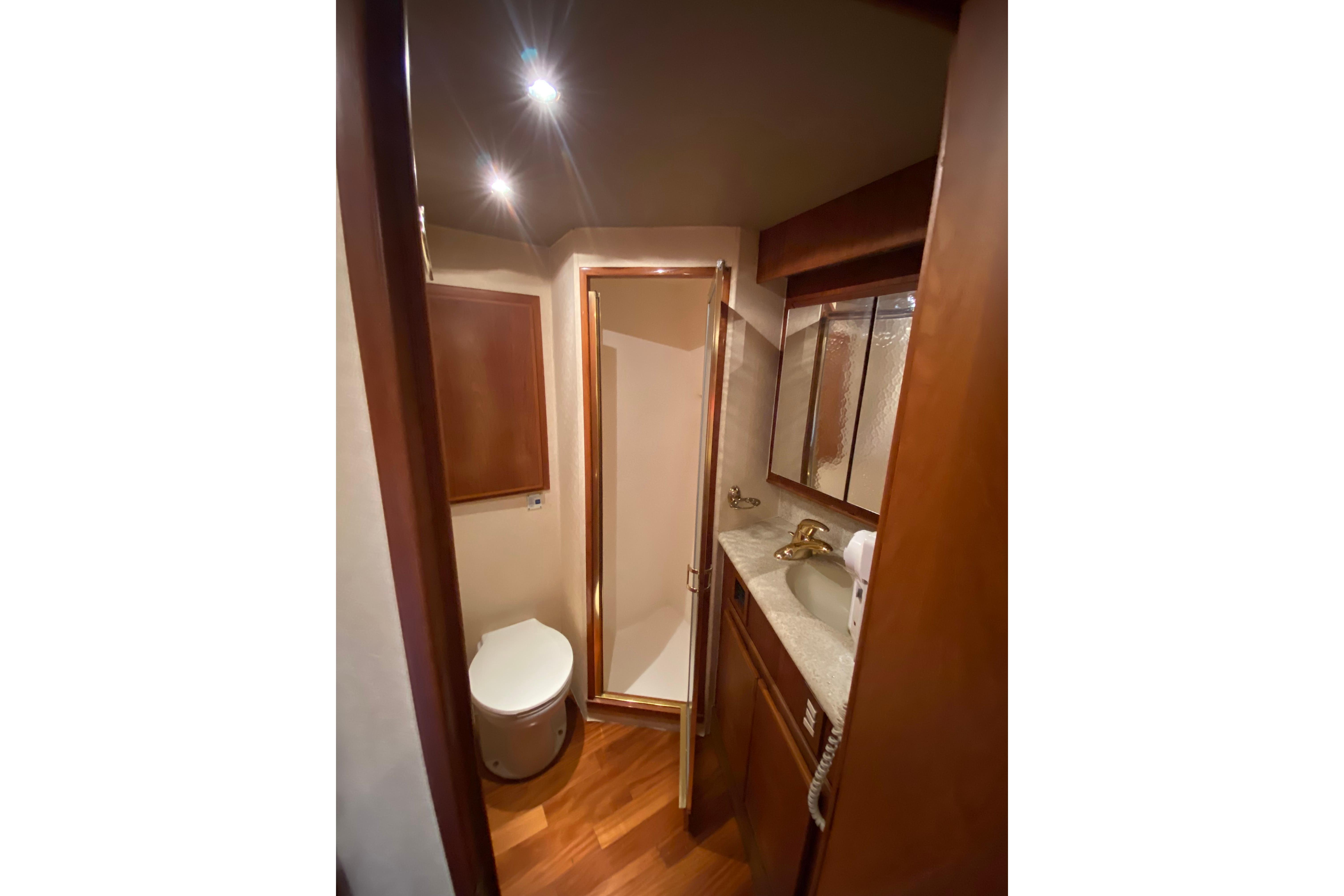 Luxurious bathroom in 2001 Egg Harbor 37 Convertible yacht with wood accents and modern fixtures.