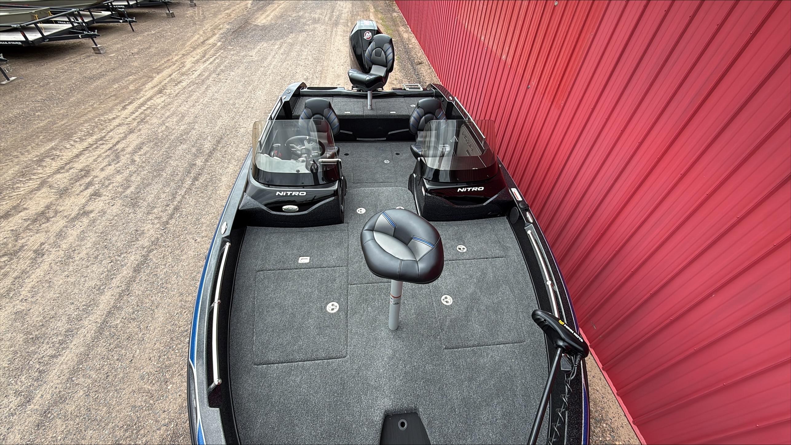 2025 Nitro ZV19 boat with dual consoles and seating, parked beside a red wall.