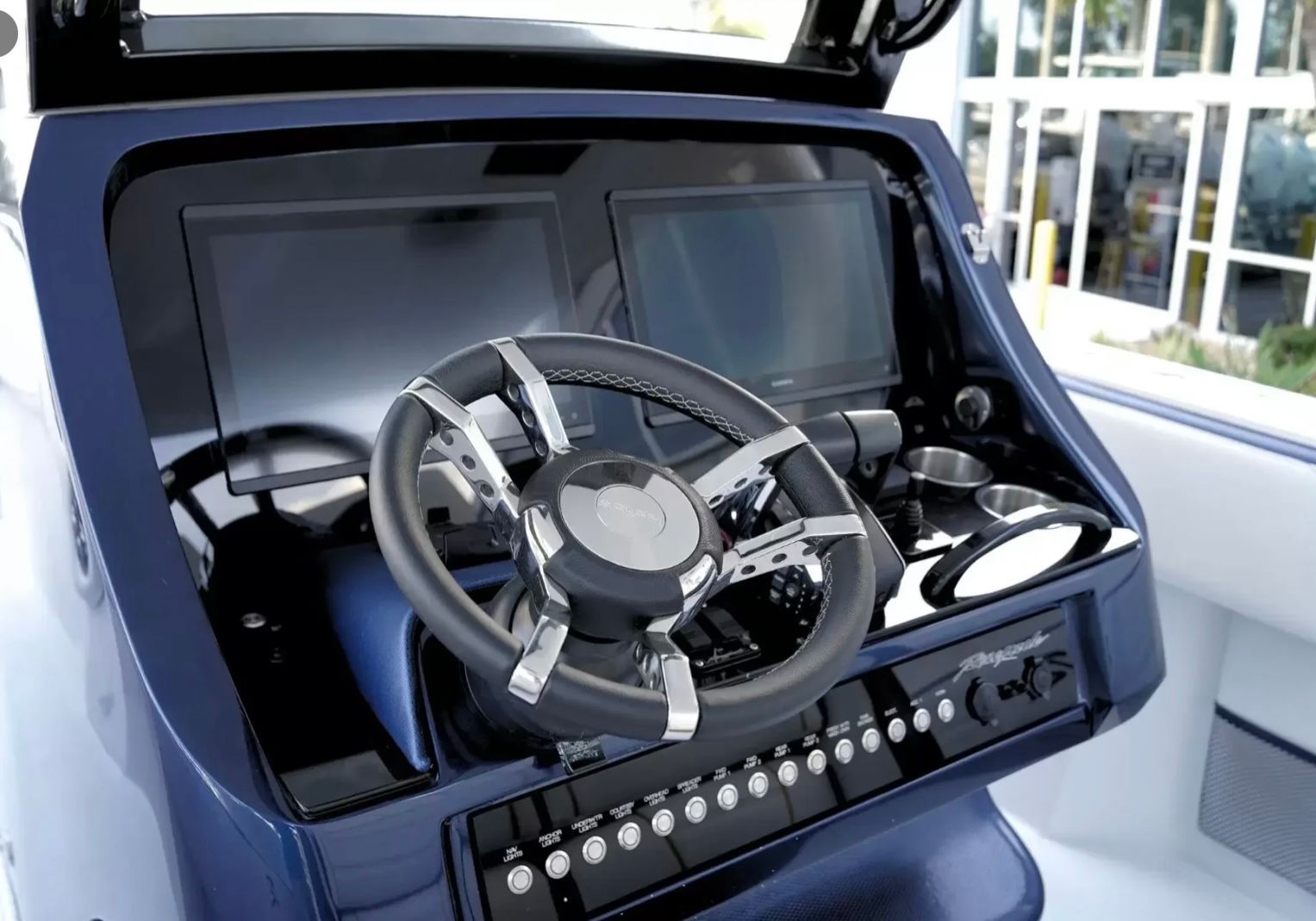 The image shows a modern boat helm with two screens and a stylish steering wheel.