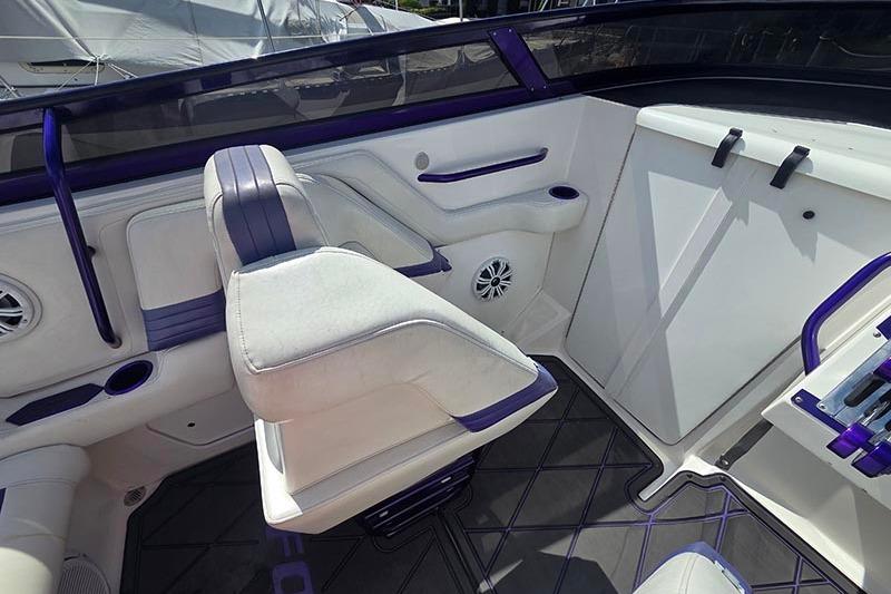 Interior of a 2004 Fountain 38 Lightning boat with white and purple seating.