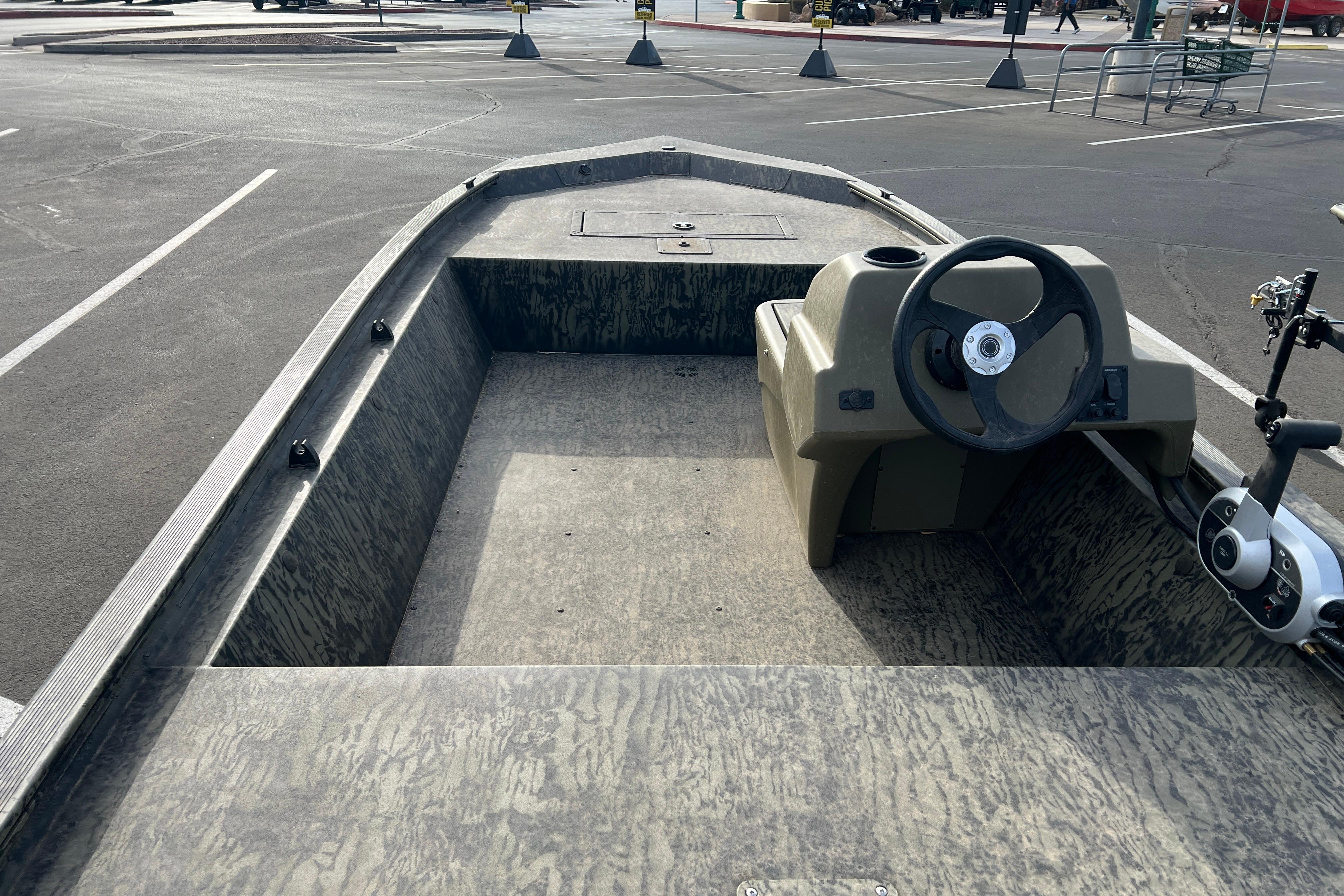 2026 Tracker Grizzly 1648 SC boat interior with steering wheel in parking lot.