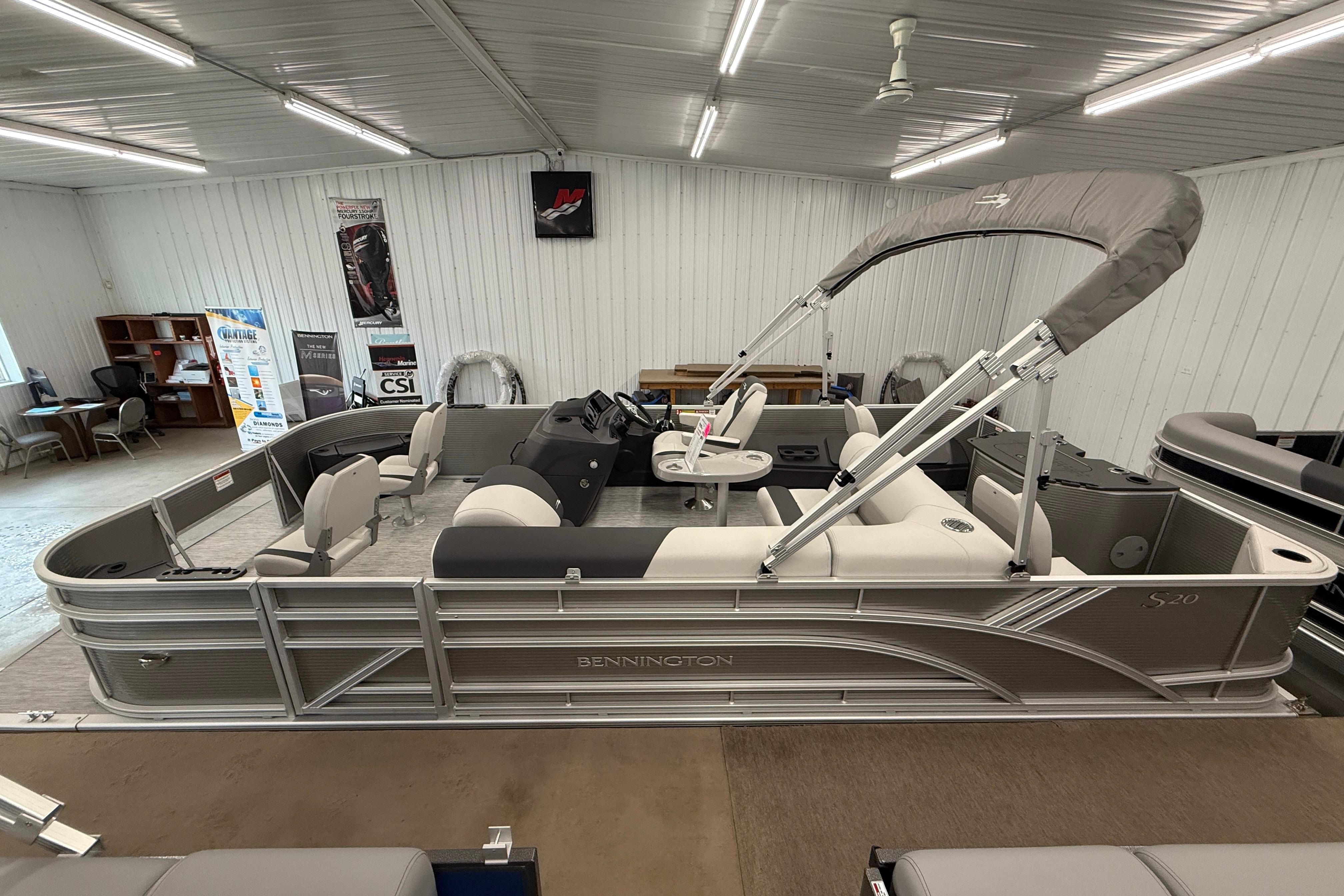 2026 Bennington 20 SF pontoon boat displayed in a showroom with canopy.