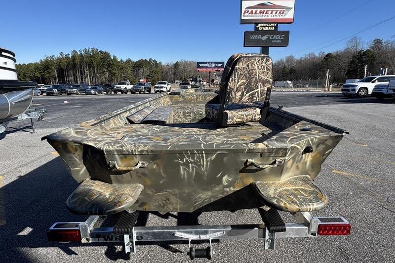 2026 War Eagle 648LDV camo boat on trailer in parking lot.