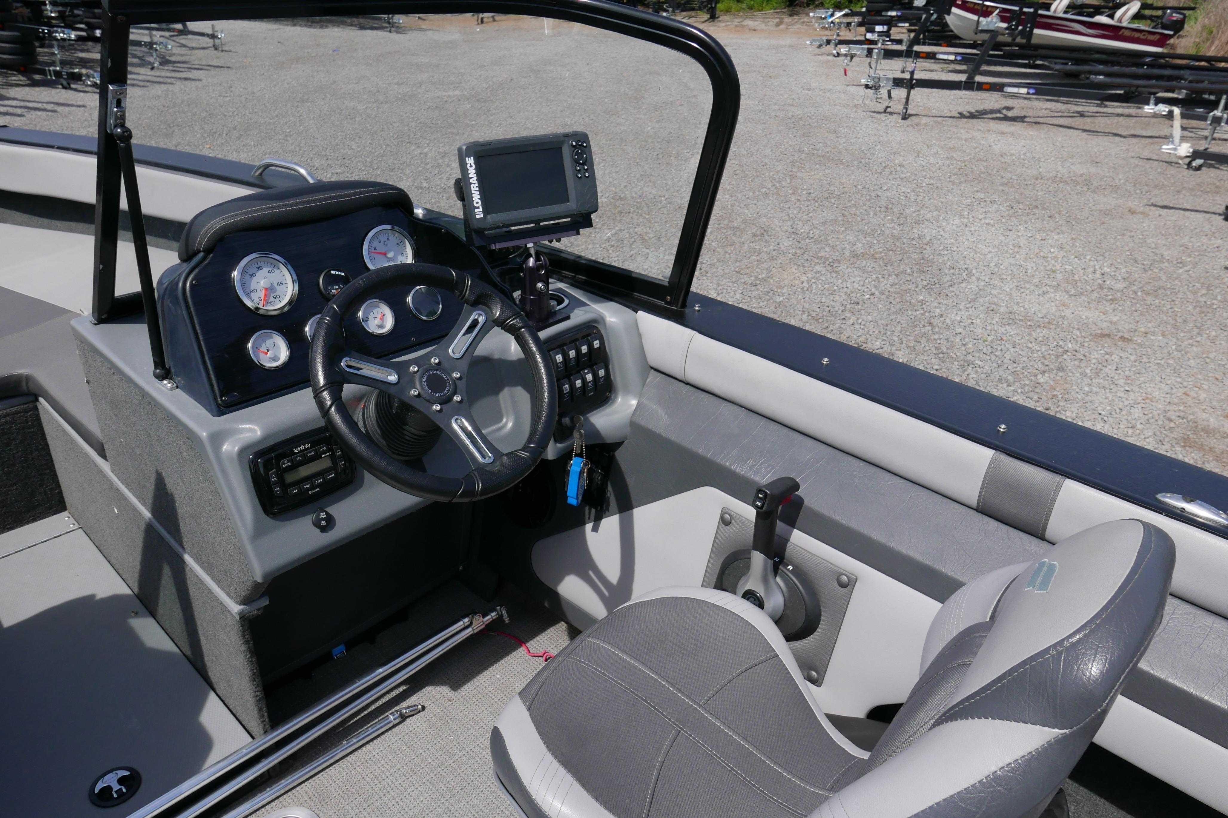 2016 Starcraft Titan 186 boat cockpit with steering wheel, gauges, and navigation system.