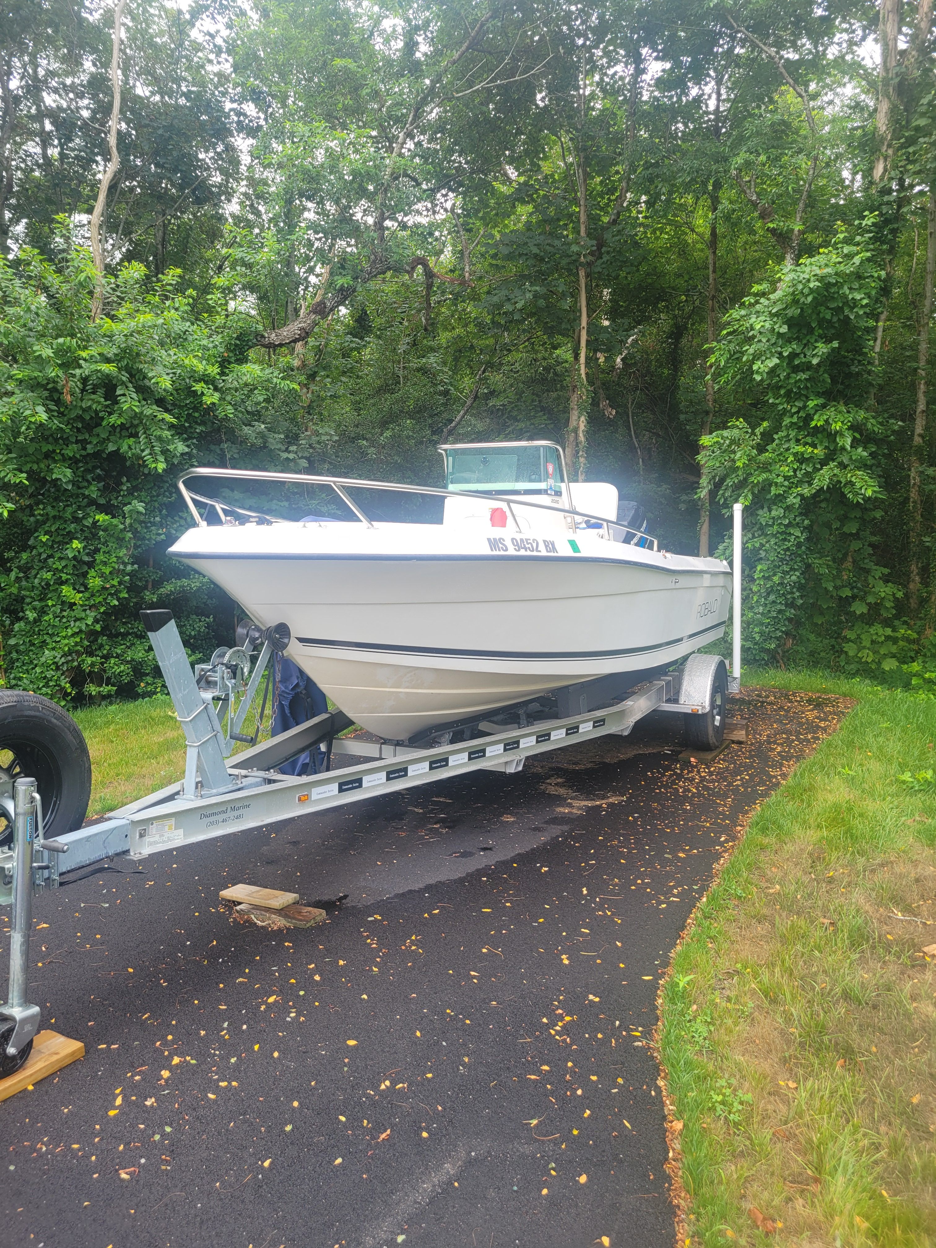 Robalo 2020 Center Console boat on trailer, surrounded by lush greenery.