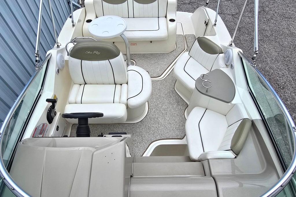 2006 Sea Ray 240 Sundancer boat interior with white seating and steering wheel.