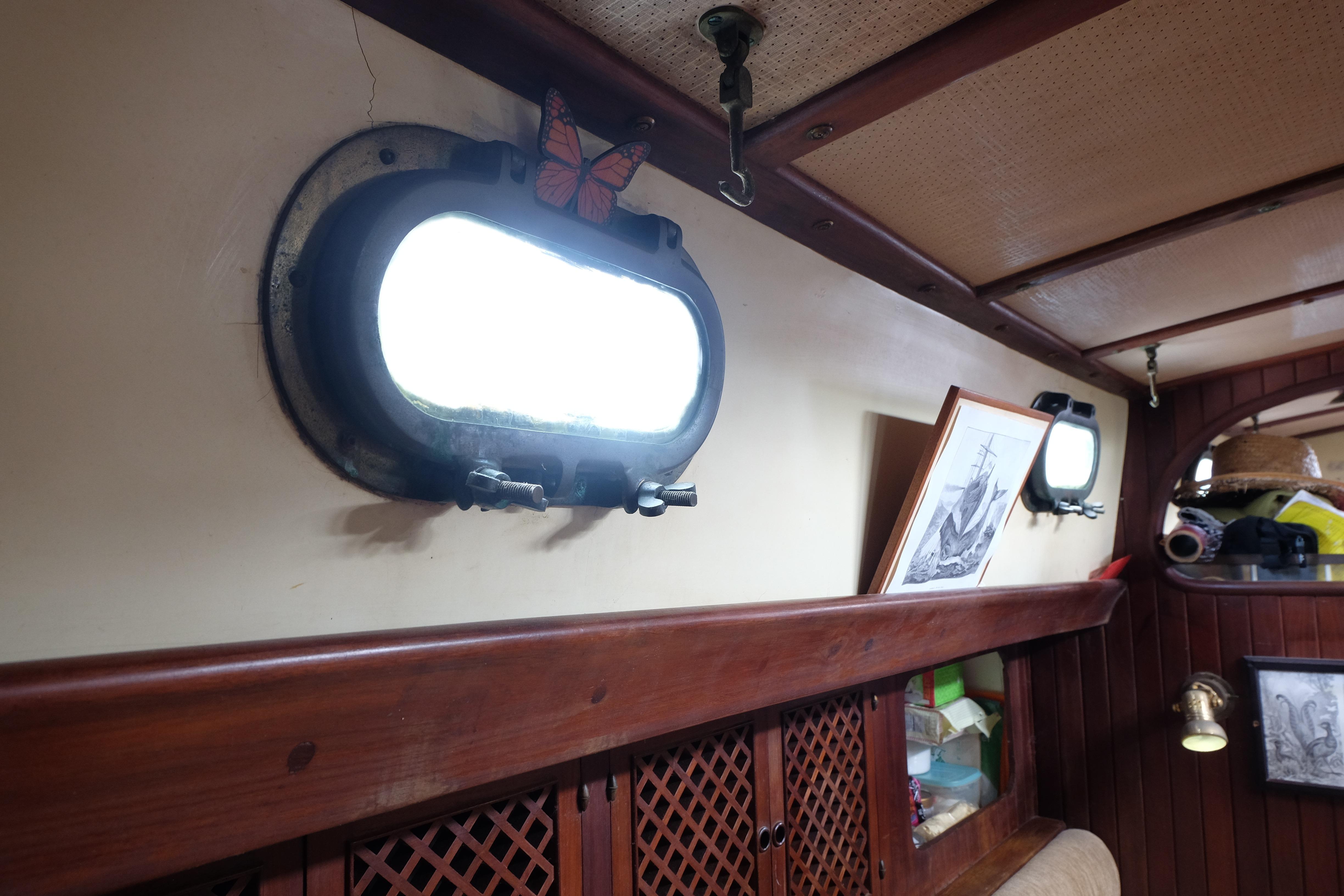 Interior of a 1979 Westwind 35 boat with portholes and nautical decor.