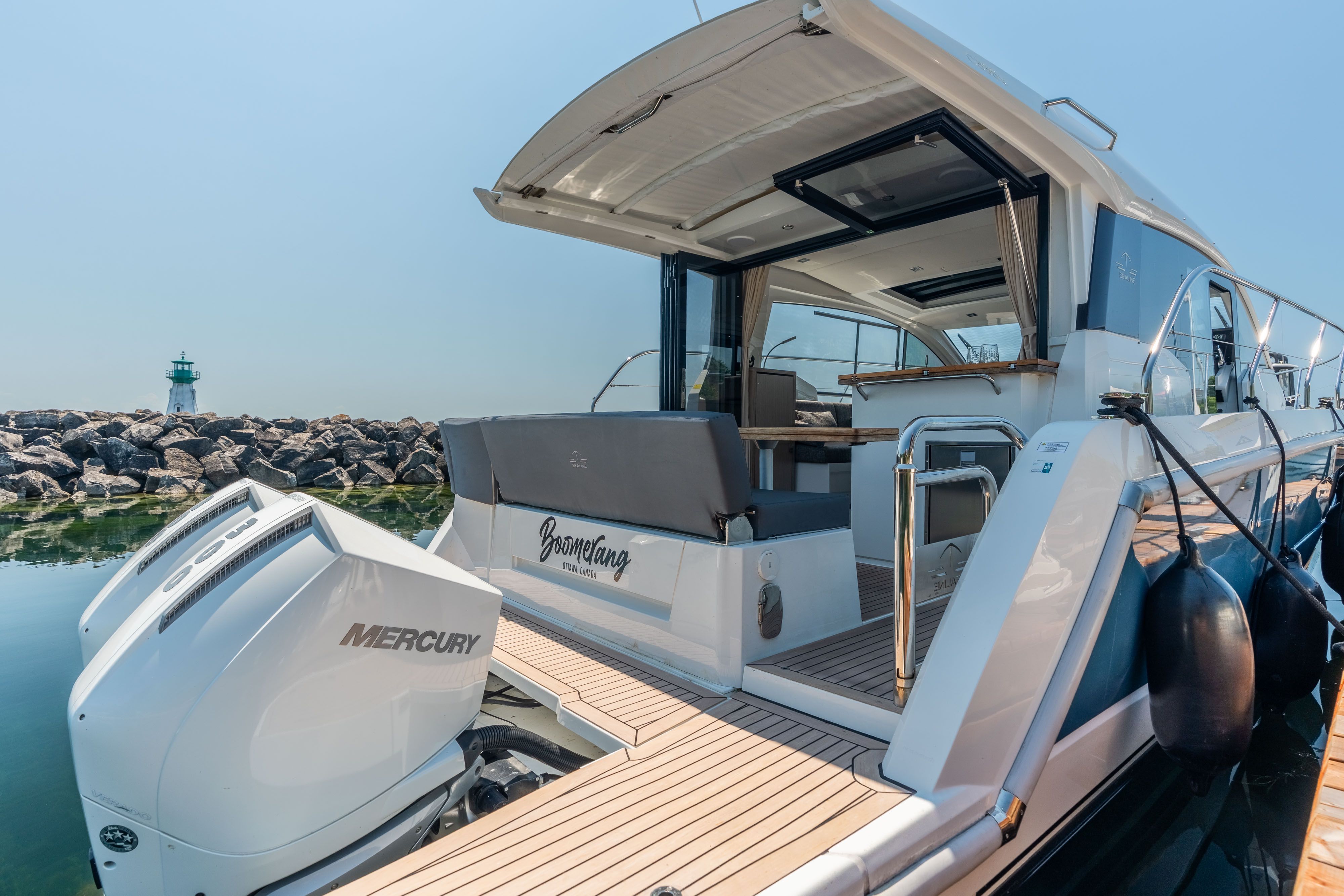 2023 Sealine C335V at dock with open cockpit and outboard motor.