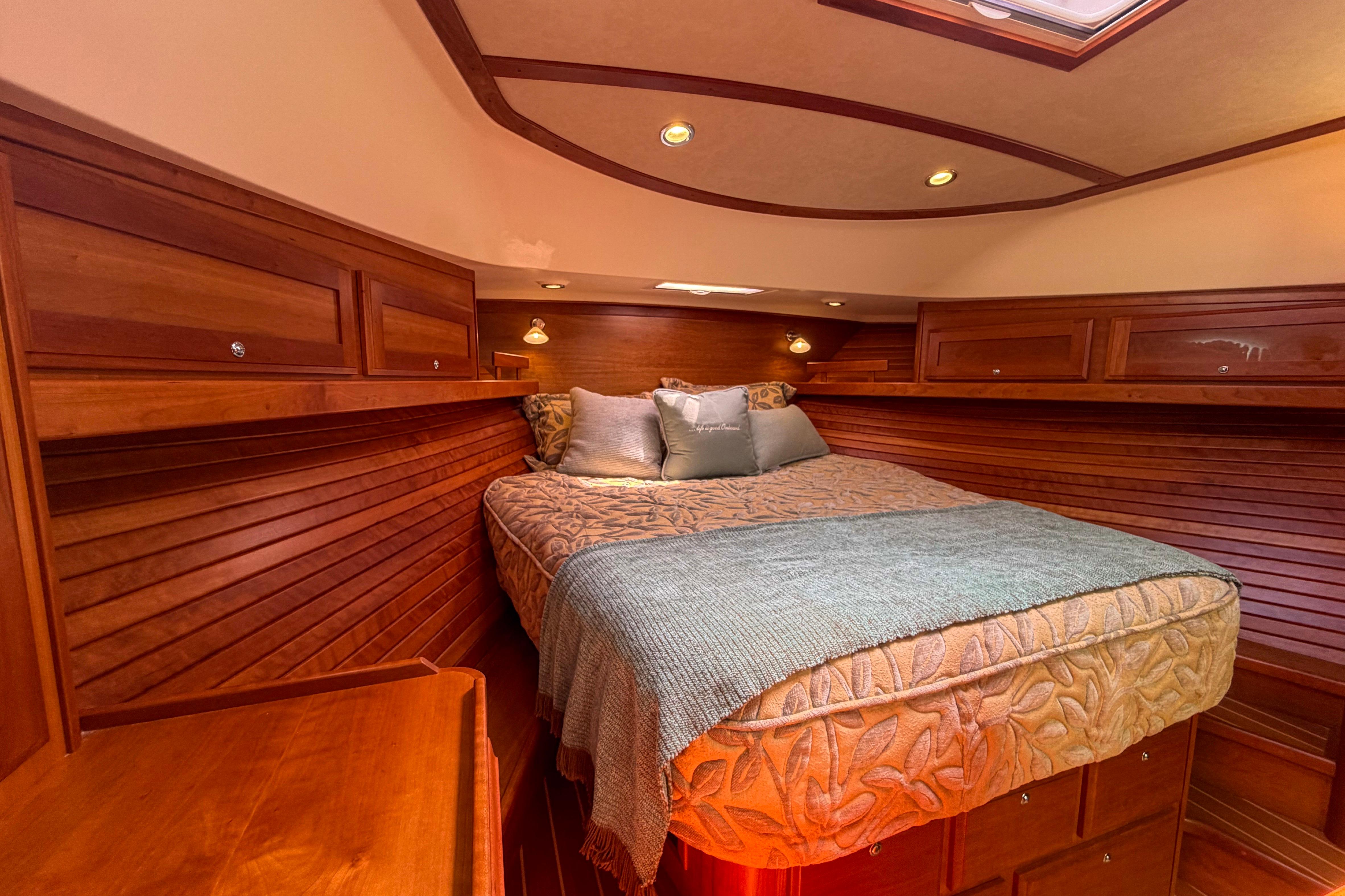 Luxurious 2013 Sabre 38 Salon Express cabin with elegant wood paneling and cozy bedding.